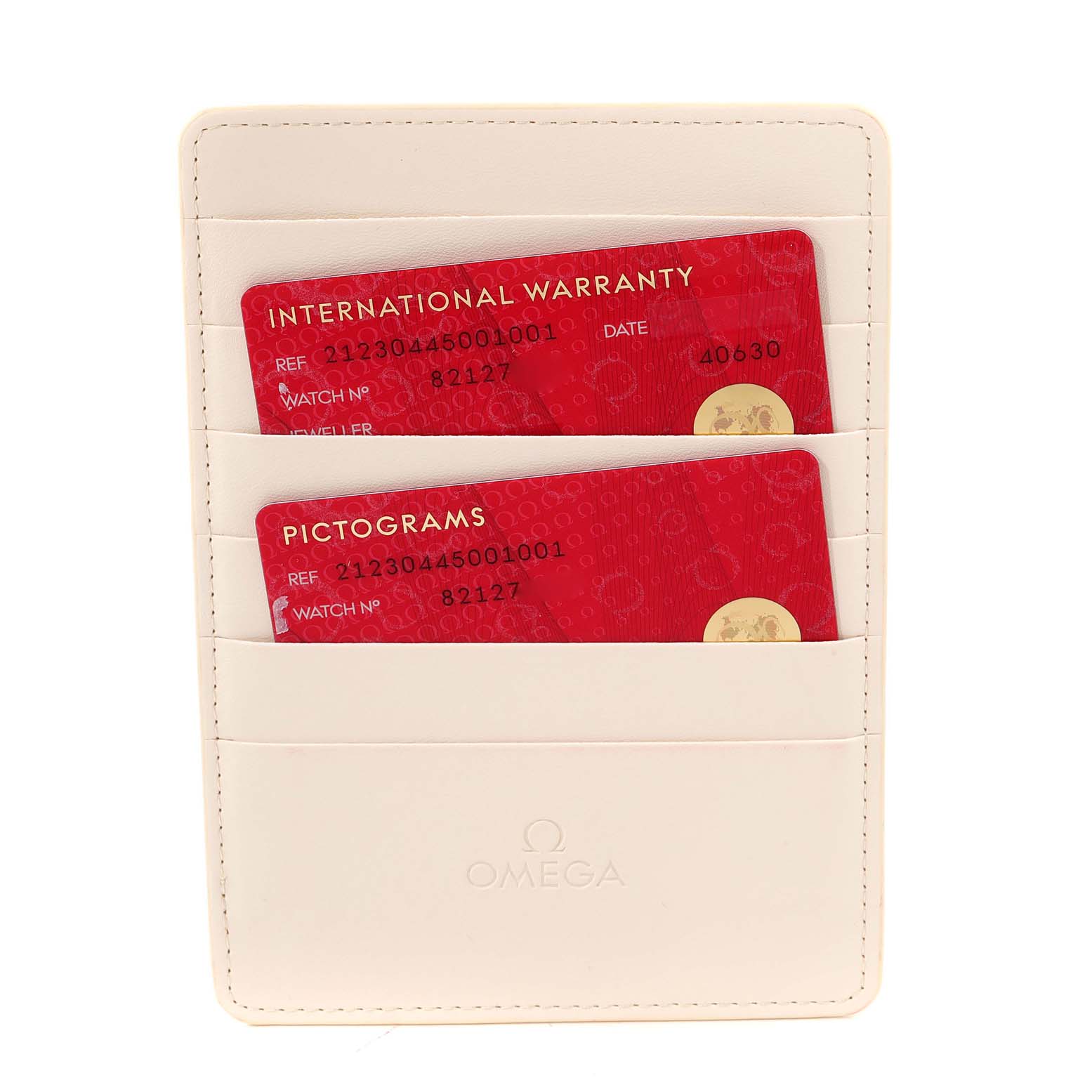 The image shows two red cards labeled "International Warranty" and "Pictograms" in a cream-colored Omega holder for a Seamaster model.