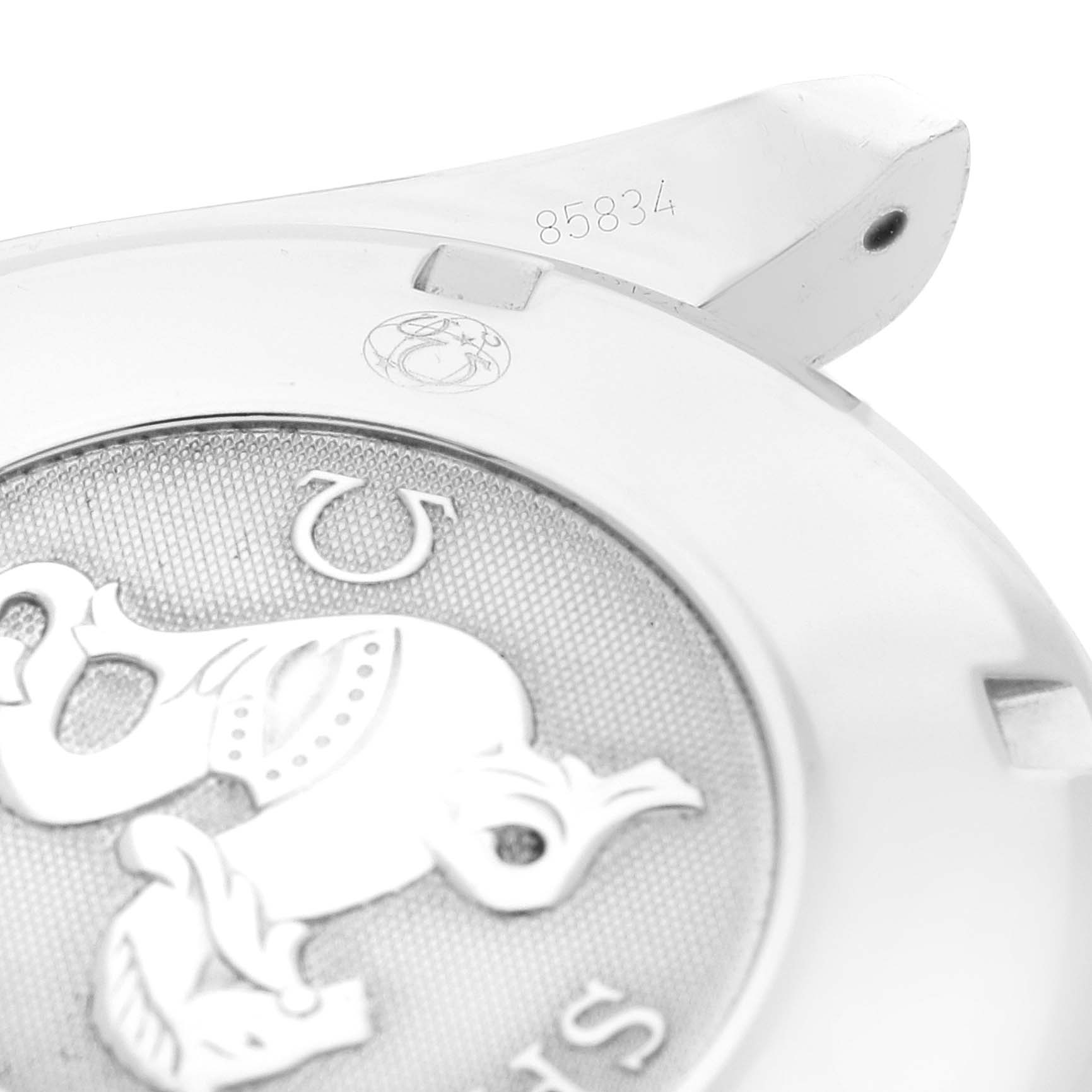 This image shows a close-up of the back case of an Omega Speedmaster 3211.30.00 Men's Stainless Steel Silver Dial 3211.30.00 Men's Stainless Steel Silver Dial watch, including part of the engraved emblem and serial number.