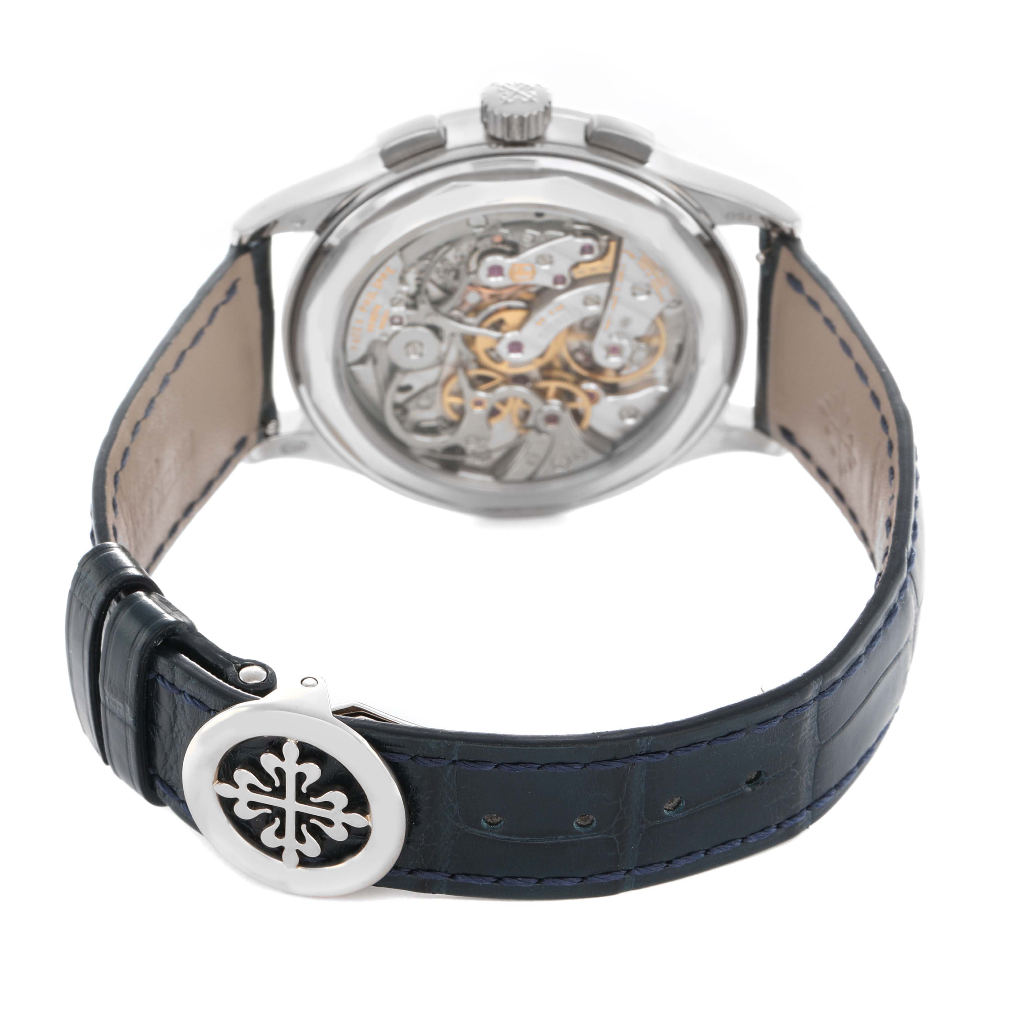 The image shows the Patek Philippe Complications 5170G-010 Men's White Gold Silver Dial watch from the back, highlighting its movement and blue leather strap with a logo clasp.