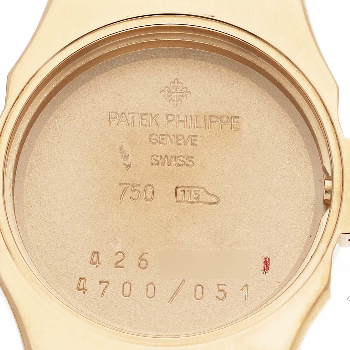 This is an image of the back case of a Patek Philippe Nautilus 4700/051 Women's Yellow Gold White Dial 4700/051 Women's Yellow Gold White Dial watch, showing the serial numbers and engravings.