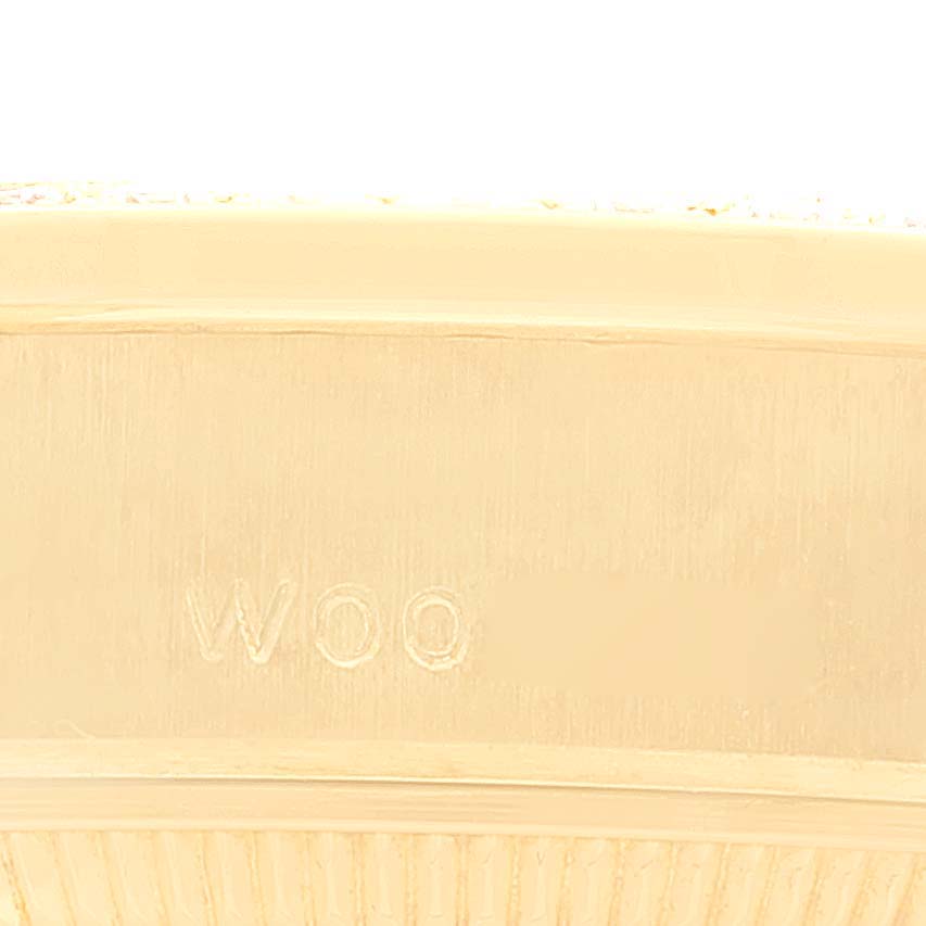 The image shows a macro view of the side of a Rolex President 69158 Women's Yellow Gold Champagne Dial 69158 Women's Yellow Gold Champagne Dial model watch, highlighting engraved markings.