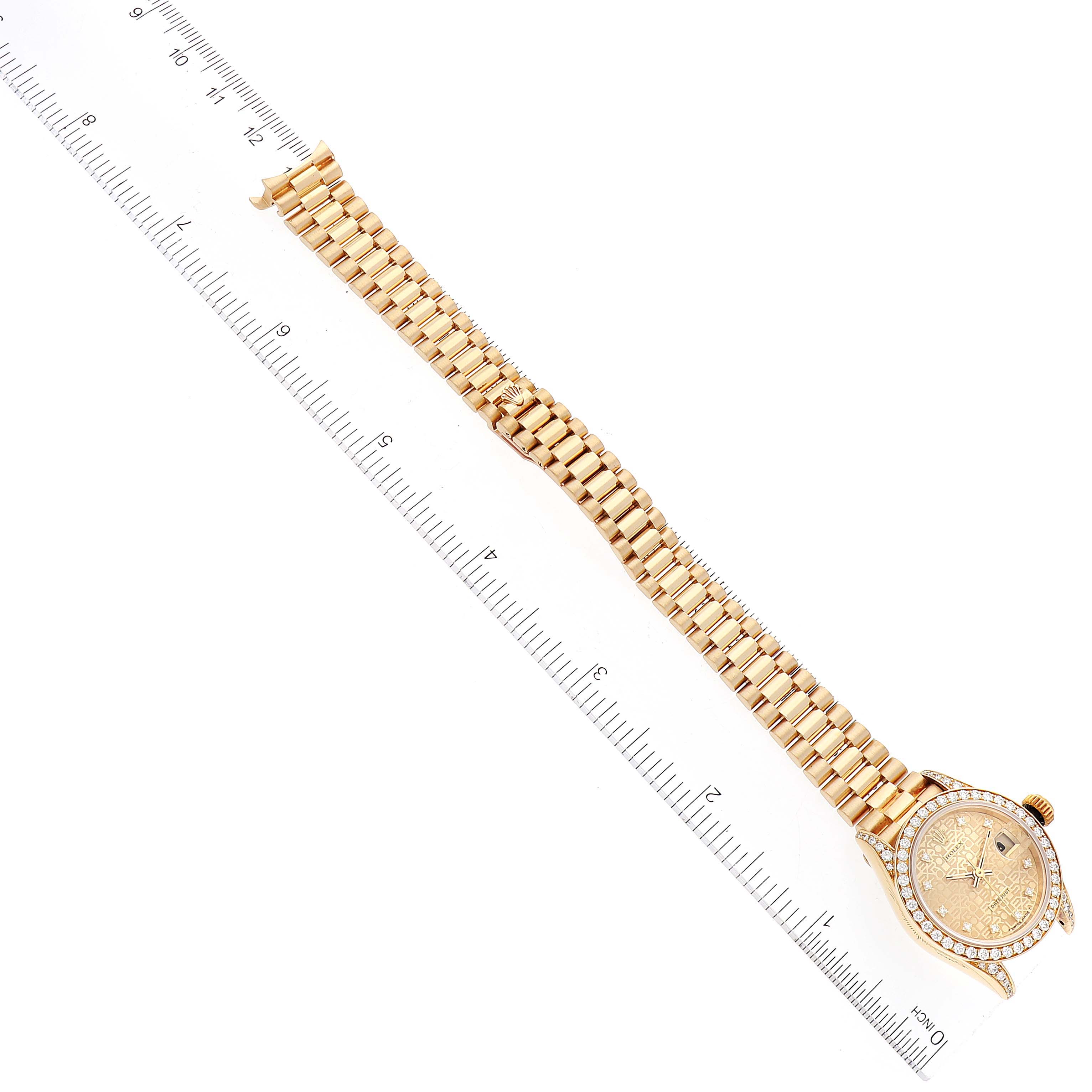The Rolex President 69158 Women's Yellow Gold Champagne Dial 69158 Women's Yellow Gold Champagne Dial model watch is shown from a top-down angle, revealing the full bracelet and face, alongside a ruler for scale.