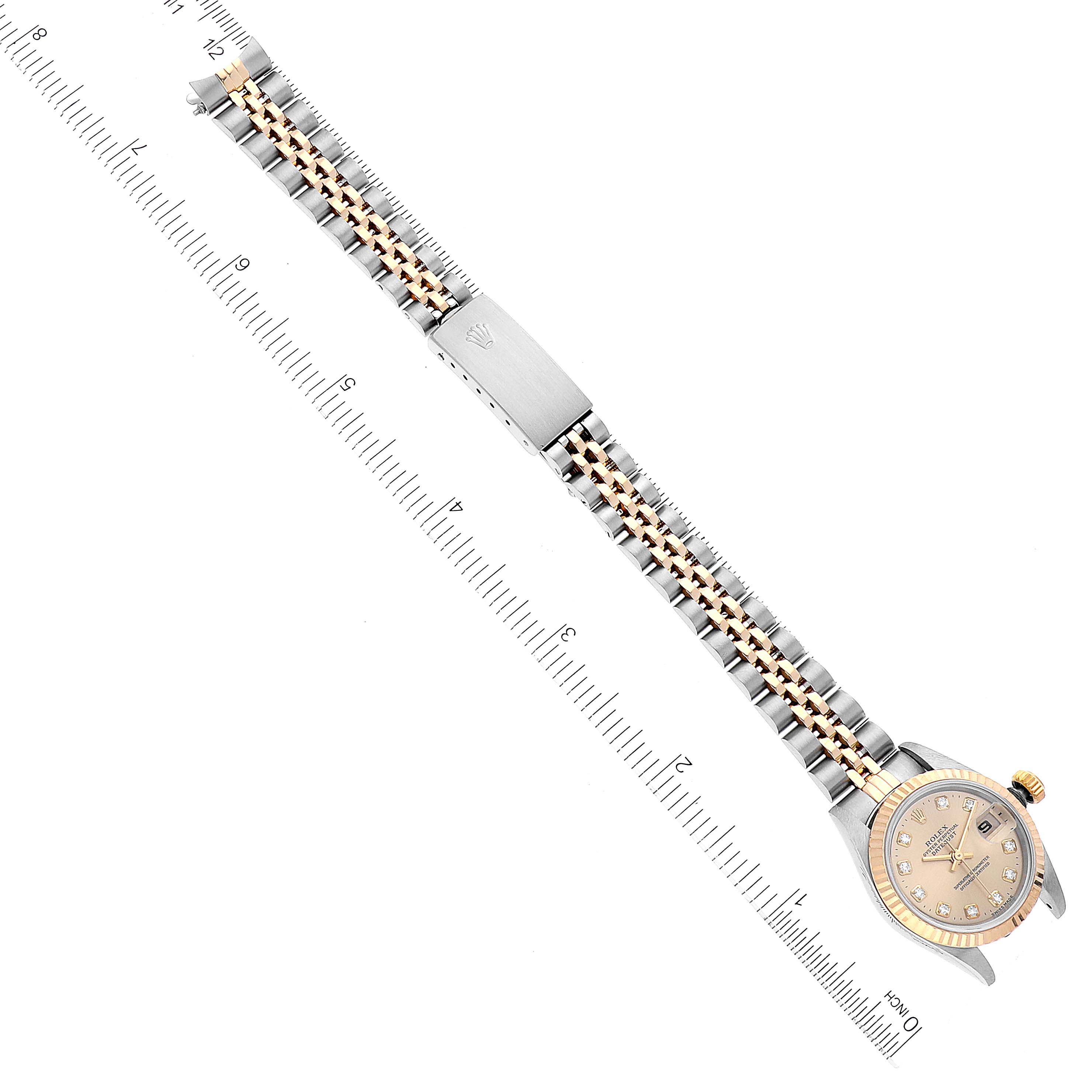 This top view image of the Rolex Datejust 69173 Women's Steel and Gold (two tone) Champagne Dial 69173 Women's Steel and Gold (two tone) Champagne Dial watch showcases the entire watch face and bracelet, placed adjacent to a ruler.