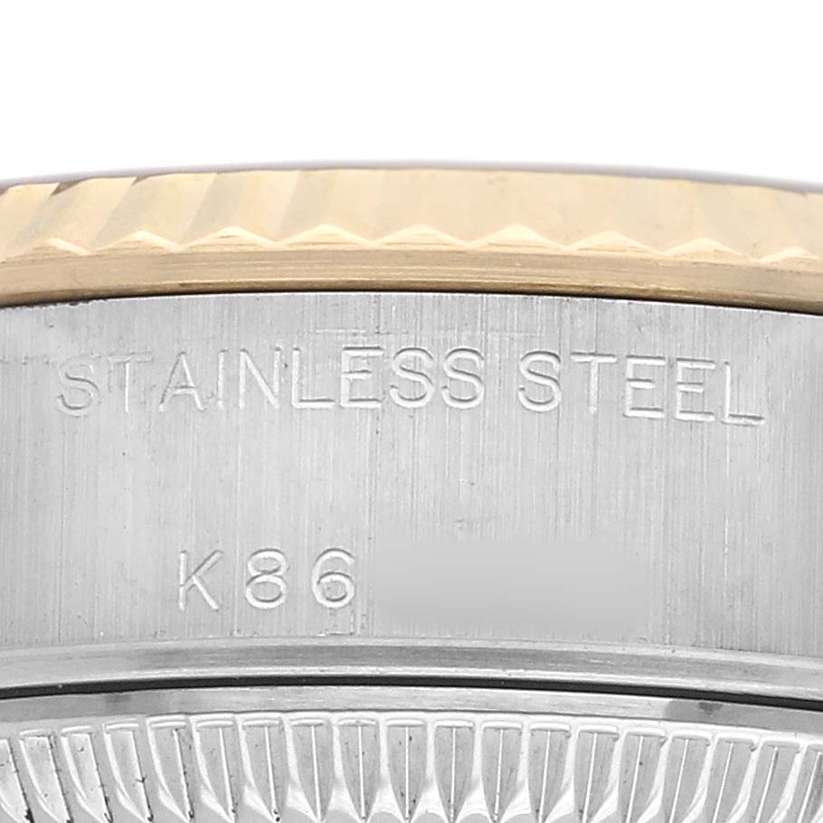 The image shows a close-up of the side engraving and bezel of a Rolex Datejust 79173 Women's Steel and Gold (two tone) Black Dial, highlighting the "STAINLESS STEEL" text.