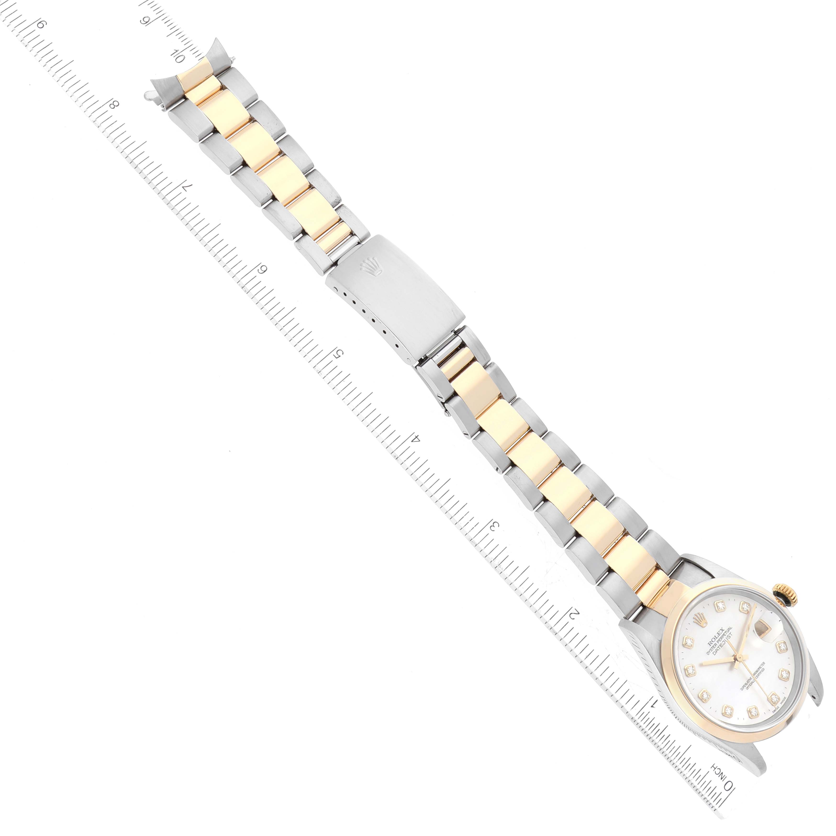 The image shows a Rolex Datejust 16203 Men's Steel and Gold (two tone) Mother of Pearl Dial 16203 Men's Steel and Gold (two tone) Mother of Pearl Dial watch from a top-down angle, displaying the face and entire bracelet with a ruler for scale.