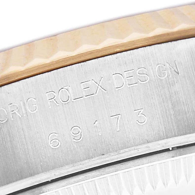 The image shows a close-up of the serial engraving on the Rolex Datejust 69173 Women's Steel and Gold (two tone) Silver Dial's side or case, highlighting the "ORIG ROLEX DESIGN" text.