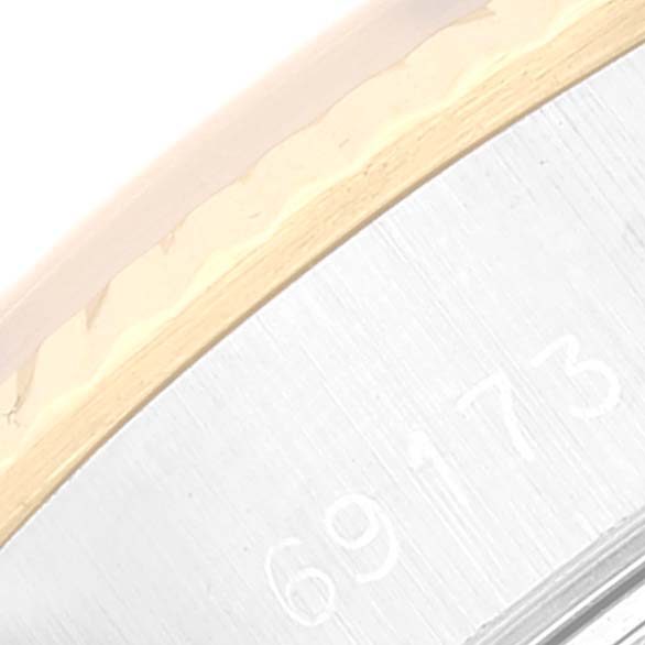 This close-up image shows the side of a Rolex Datejust 69173 Women's Steel and Gold (two tone) White Dial 69173 Women's Steel and Gold (two tone) White Dial, featuring part of the bezel and case with engraved numbers.