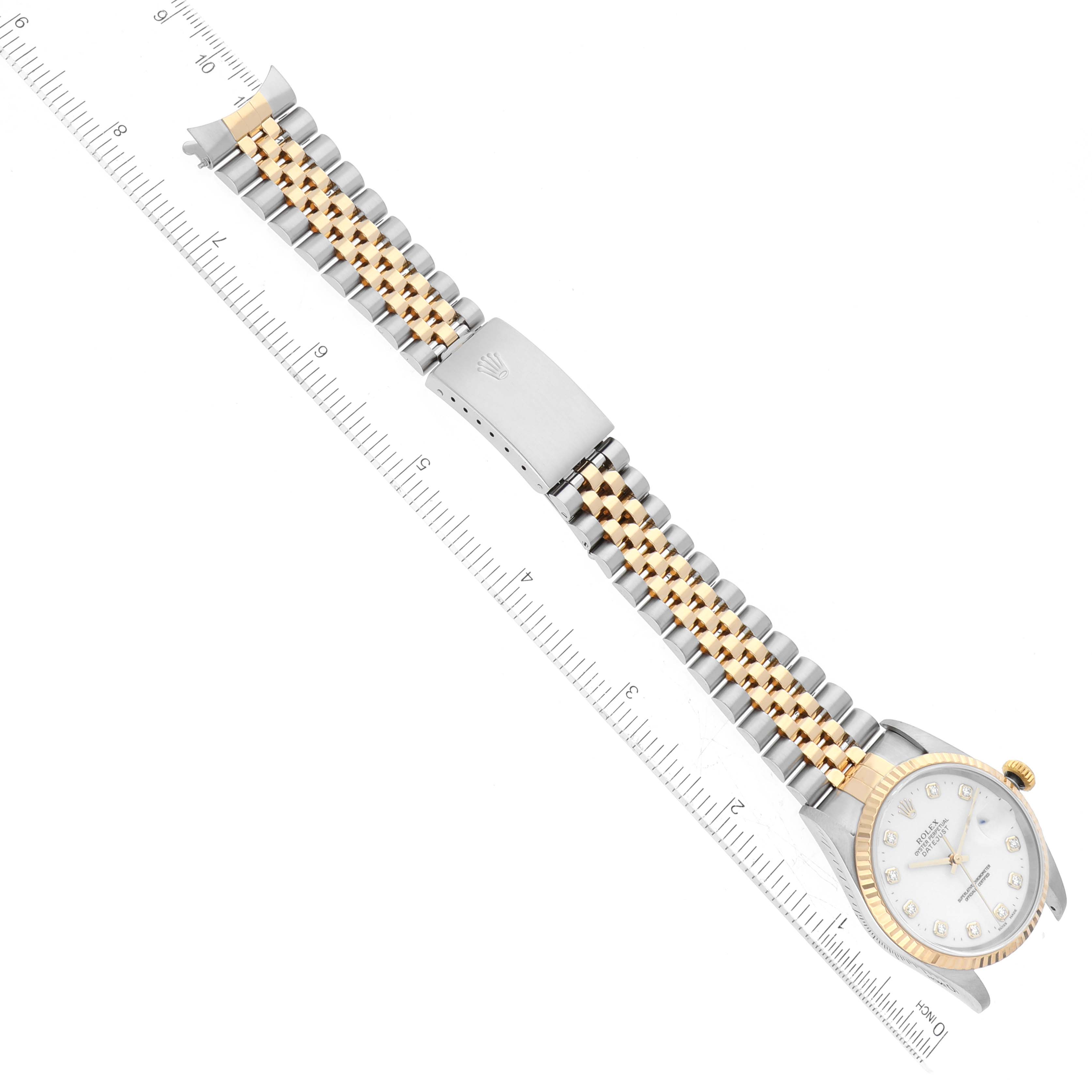 The image shows a Rolex Datejust 16233 Men's Steel and Gold (two tone) White Dial 16233 Men's Steel and Gold (two tone) White Dial watch, featuring its face, bezel, and Jubilee bracelet laid flat alongside a ruler.