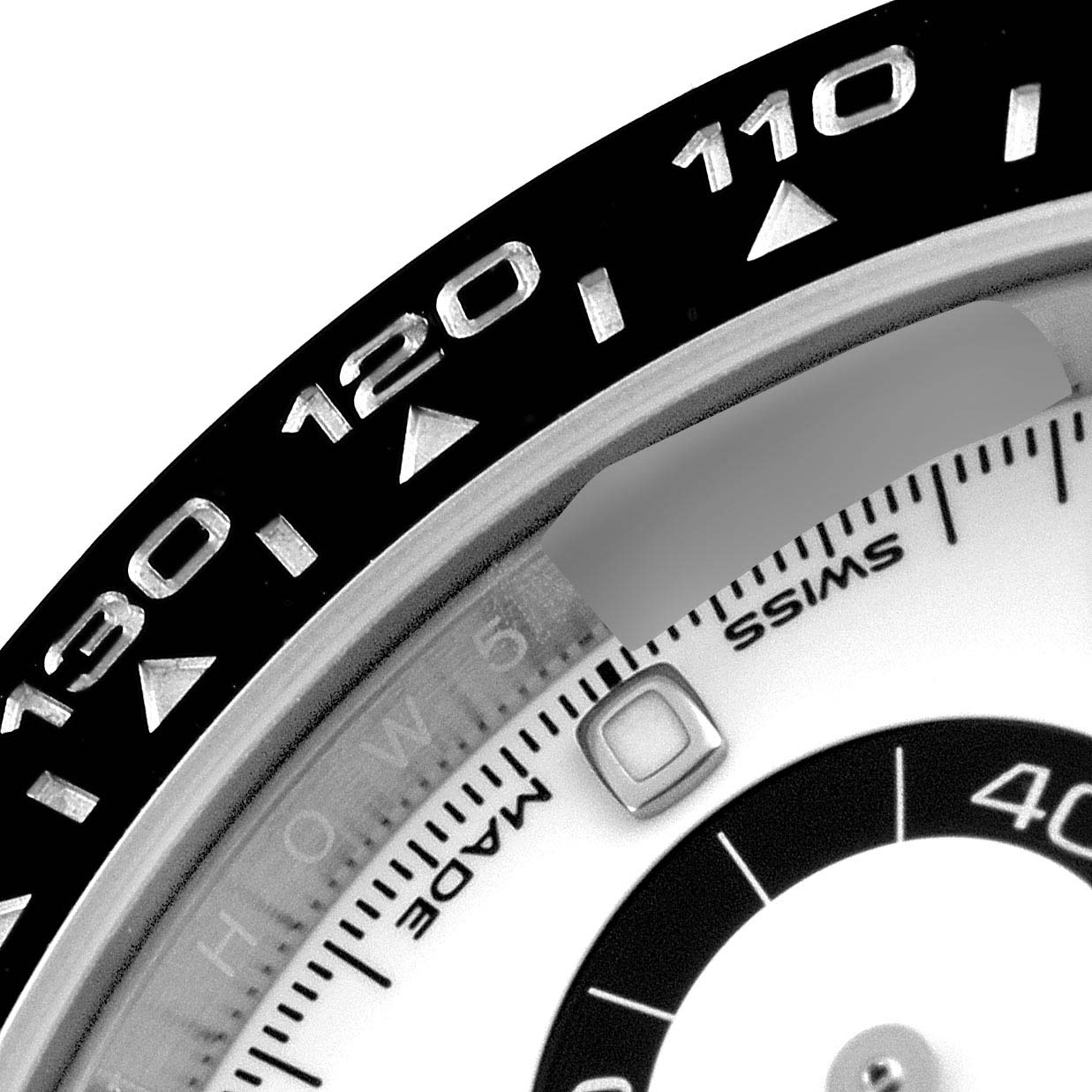 The image shows a close-up of the bezel and part of the dial of a Rolex Daytona 116500 Men's Stainless Steel White Dial 116500 Men's Stainless Steel White Dial watch with "SWISS MADE" visible.