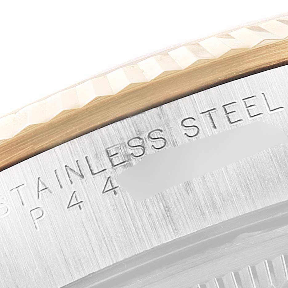 This image shows a close-up of the fluted bezel and part of the stainless steel case back of a Rolex Oyster Perpetual 14233 Men's Steel and Gold (two tone) Black Dial 14233 Men's Steel and Gold (two tone) Black Dial watch.