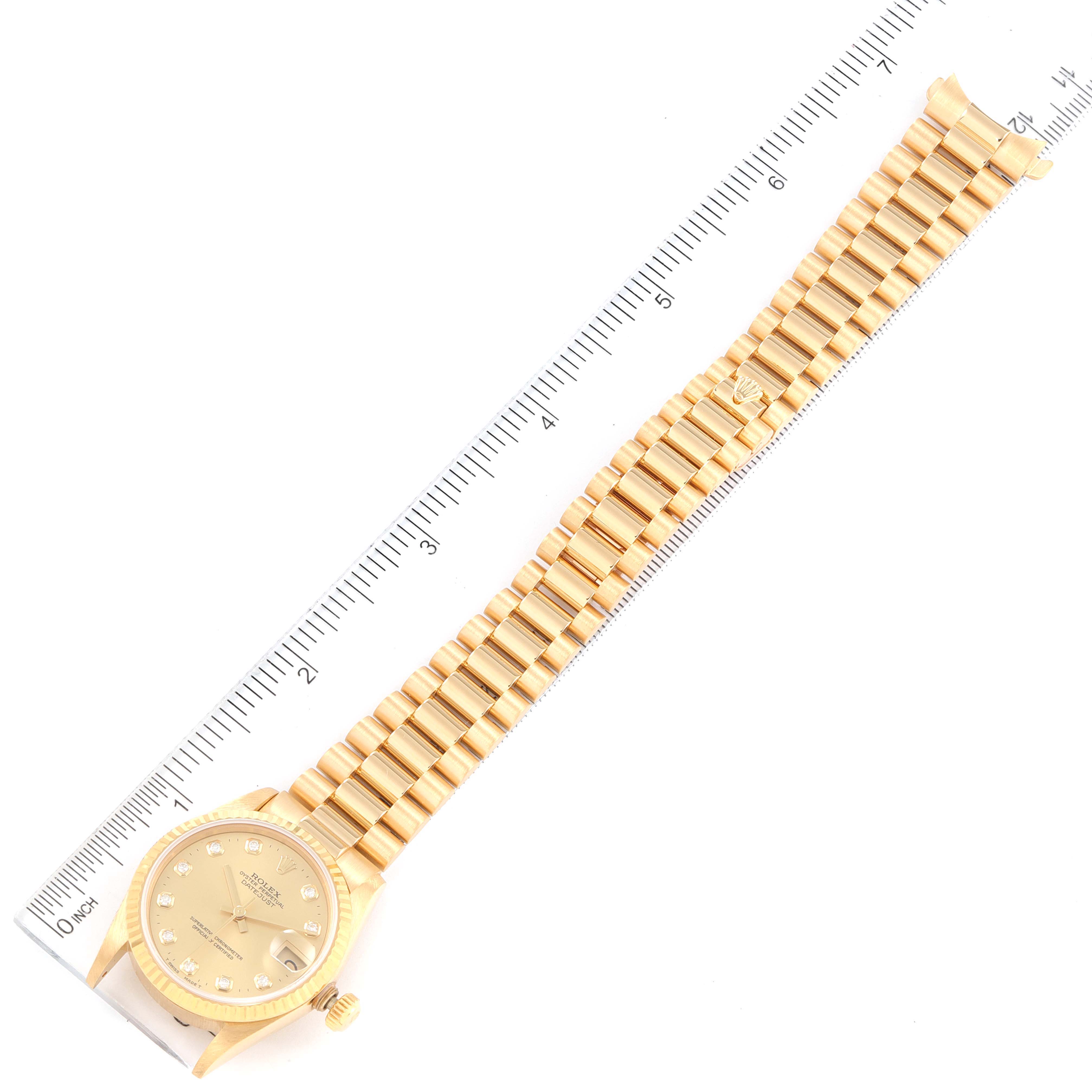 The image shows an overhead view of a Rolex President 68278 Women's Yellow Gold Champagne Dial 68278 Women's Yellow Gold Champagne Dial model watch with its bracelet extended along a ruler for scale.