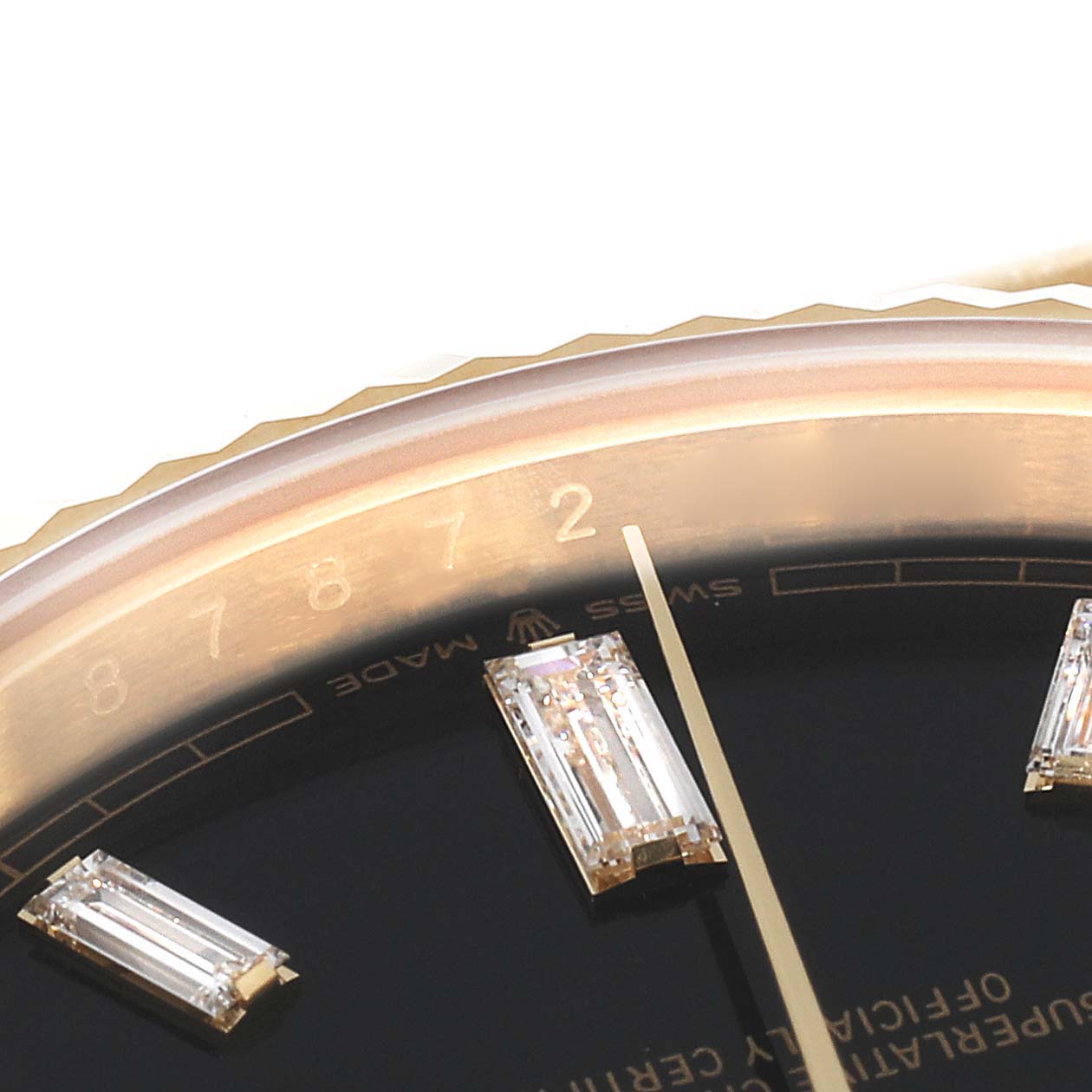 This close-up angle of the Rolex President 228238 Men's Yellow Gold Black Dial 228238 Men's Yellow Gold Black Dial model watch shows part of the dial, diamonds, and the edge of the bezel.
