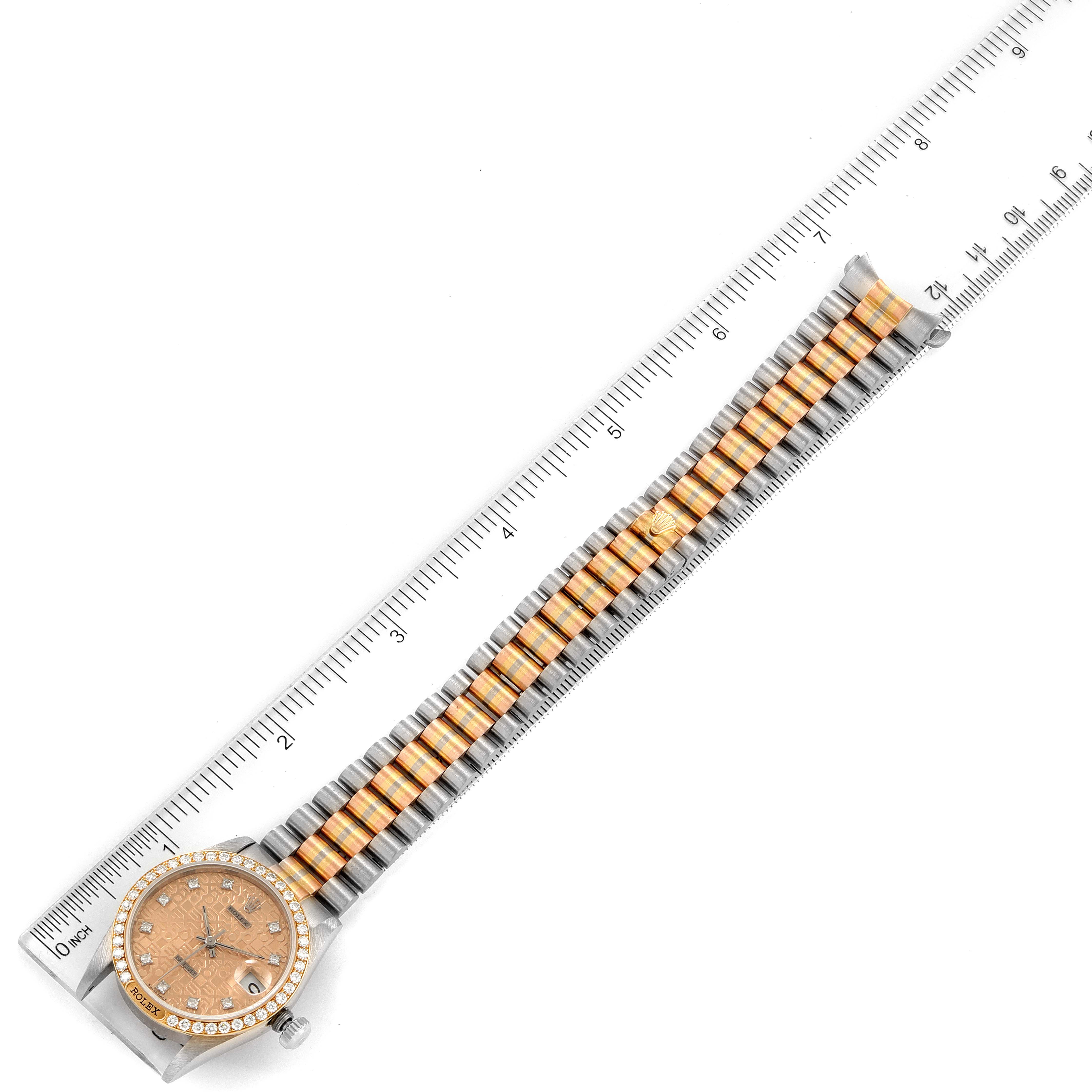 The Rolex Mid-Size 68149 Women
s White Gold Brown Dial 68149 Women
s White Gold Brown Dial watch is shown from a top-down view, with its full band and face visible, placed alongside a ruler for size reference.