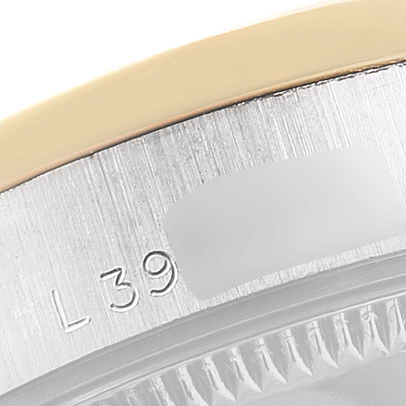This image shows a close-up of the case and bezel edge of a Mid-Size Rolex watch, highlighting the engraved serial numbers.