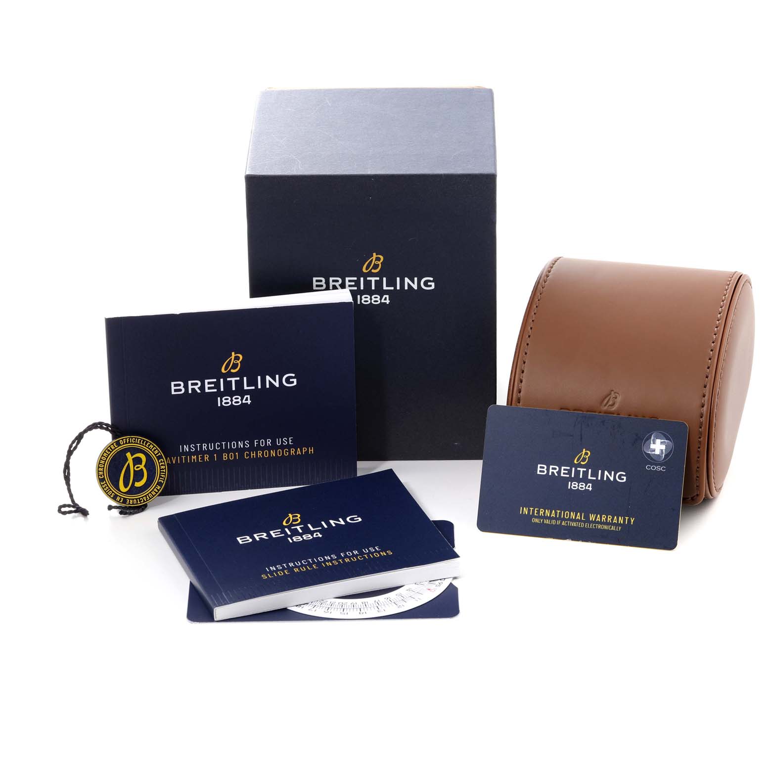 The image shows a Navitimer model by Breitling with packaging, manuals, warranty card, tag, and a brown leather watch case.