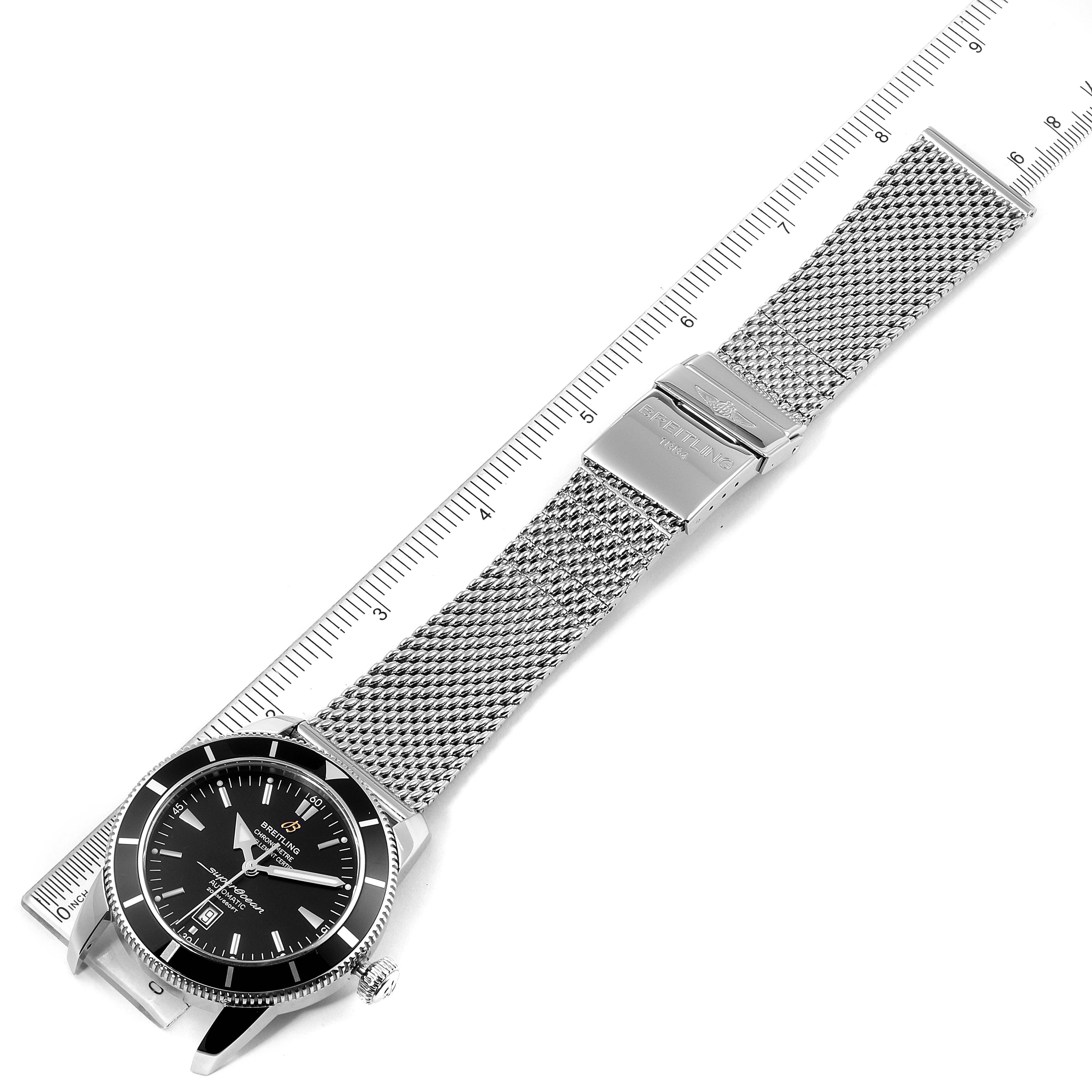 The image shows a Breitling Superocean A17320 Men's Stainless Steel Black Dial A17320 Men's Stainless Steel Black Dial watch laid flat with the face and mesh bracelet visible beside a ruler.