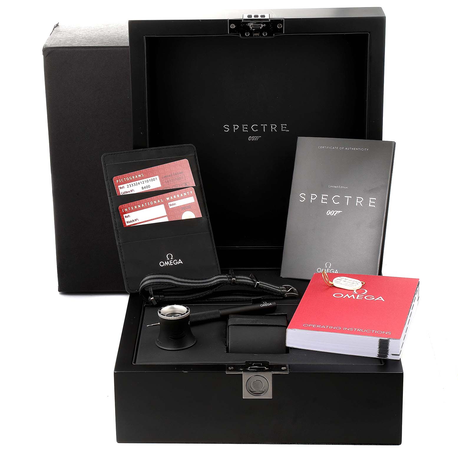 The image shows the box and accessories for the Omega Seamaster 233.32.41.21.01.001 Men's Stainless Steel Black Dial 233.32.41.21.01.001 Men's Stainless Steel Black Dial "SPECTRE" model, including booklets, a warranty card, and a watch tool.