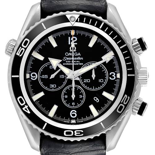 The Omega Planet Ocean watch is shown from a front angle, highlighting its black dial, bezel, chronograph subdials, and luminous markers.