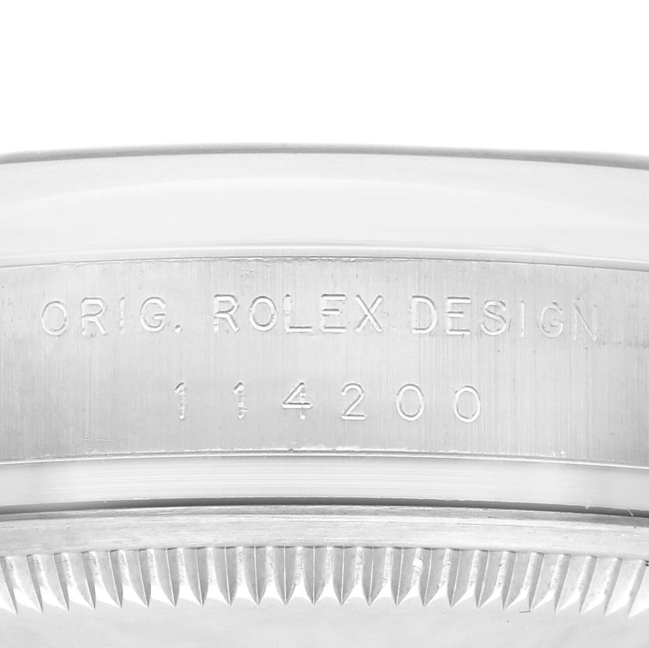 The image shows the side of a Rolex Air-King 114200 Men's Stainless Steel Silver Dial 114200 Men's Stainless Steel Silver Dial watch case, focusing on the engraved text and bezel edge.