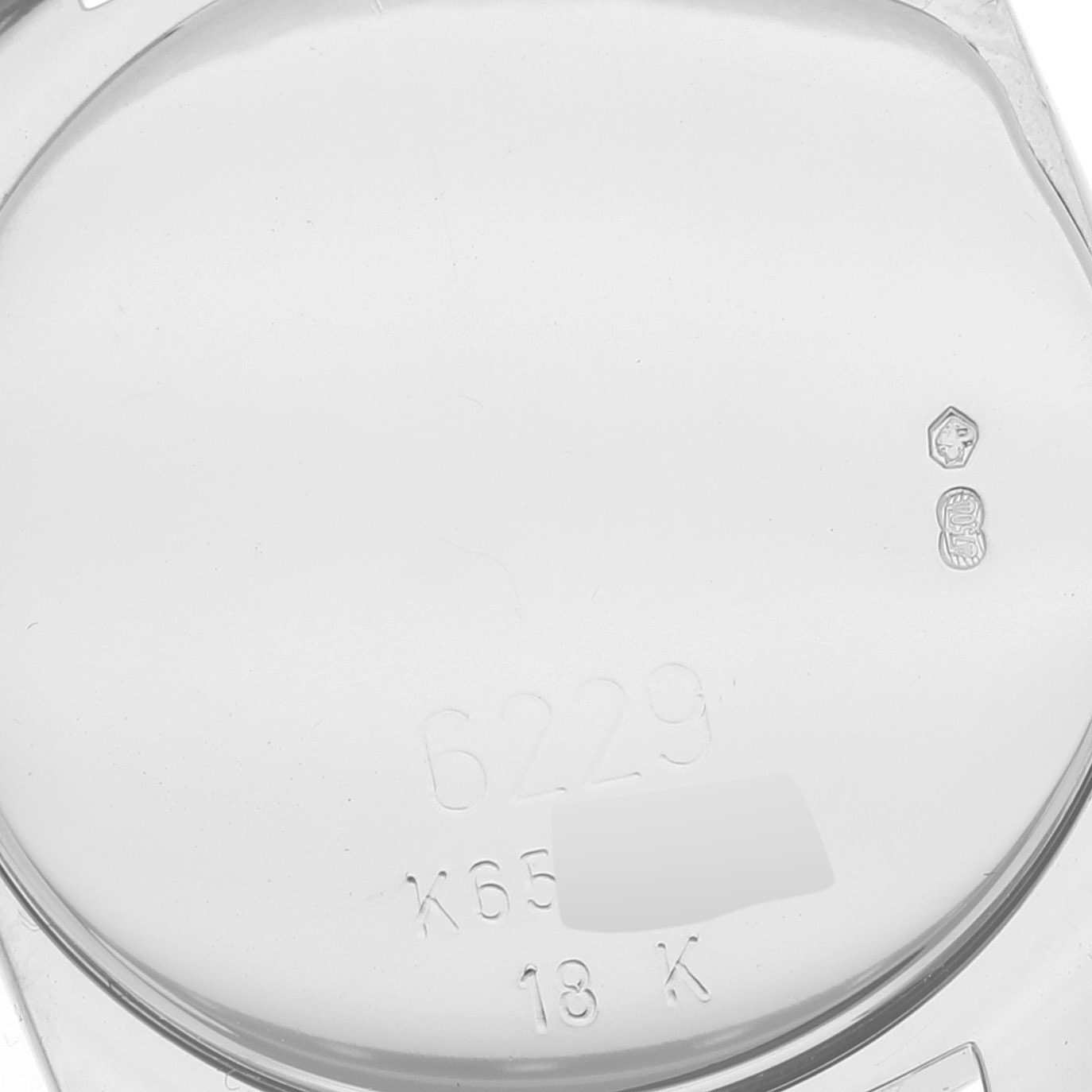 This is a close-up view of the inner case back of a Rolex Cellini 6229 Women's White Gold White Dial 6229 Women's White Gold White Dial watch, showing hallmarks, model number 6229, and material information (18K).
