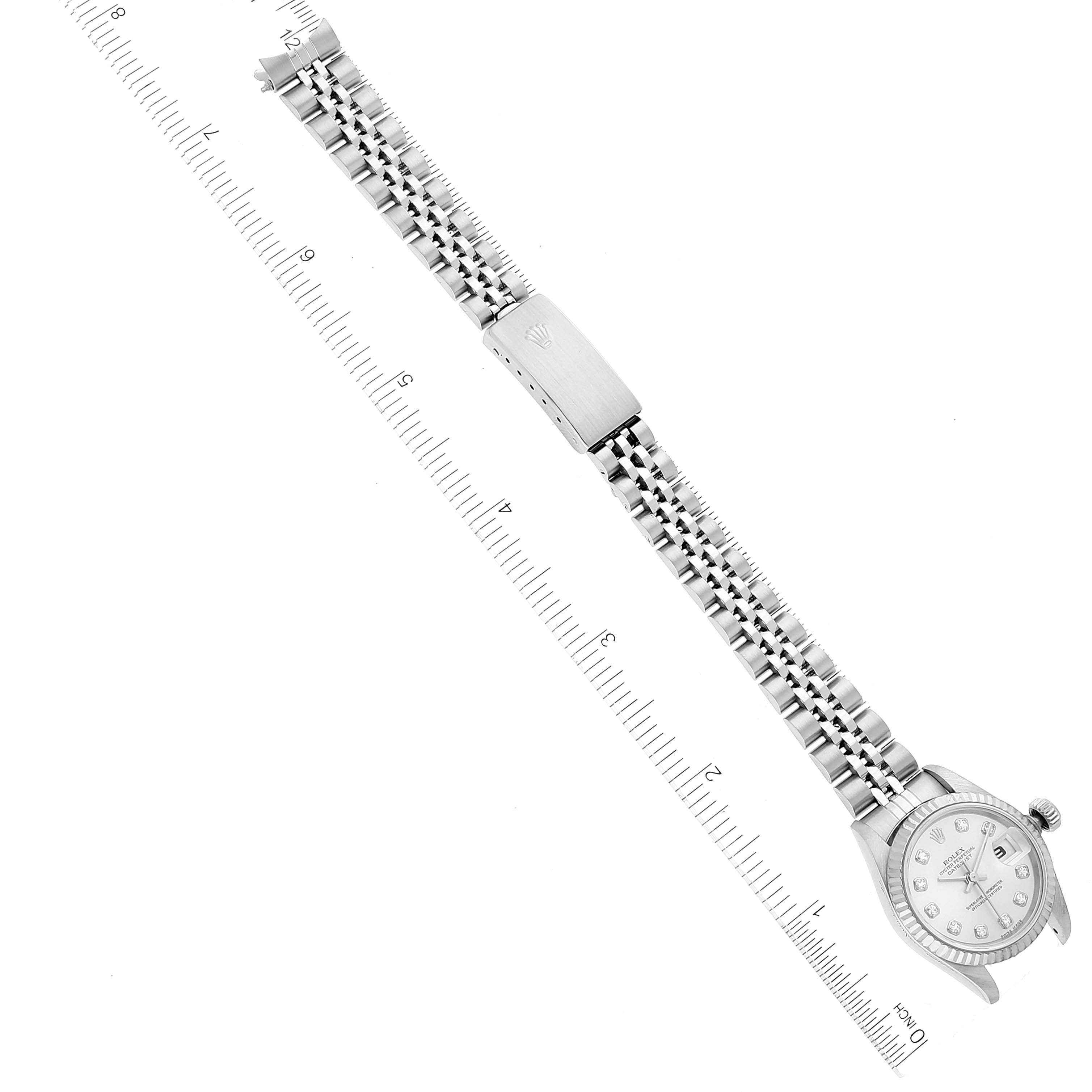 The image shows a top-down view of a Rolex Datejust 79174 Women's Stainless Steel Silver Dial 79174 Women's Stainless Steel Silver Dial watch, including the bracelet and clasp, alongside a ruler.