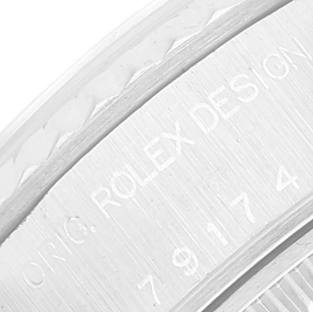 This image shows an engraved part of the bezel from a Rolex Datejust 79174 Women's Stainless Steel Silver Dial 79174 Women's Stainless Steel Silver Dial watch, displaying the text "ORIG. ROLEX DESIGN" and part of a serial number.