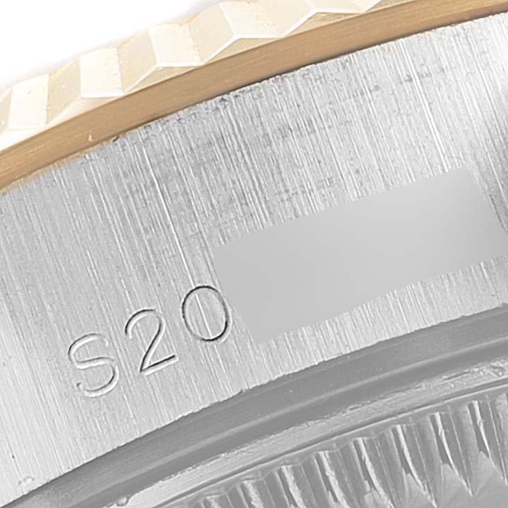 The image shows a close-up angle of the side of the case and bezel of a Rolex Datejust 69173 Women
s Steel and Gold (two tone) Champagne Dial 69173 Women
s Steel and Gold (two tone) Champagne Dial watch, featuring inscription details.