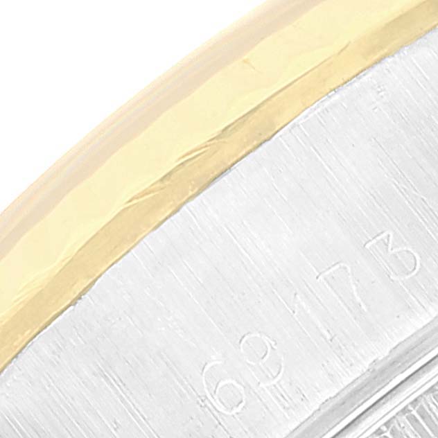 The image shows a close-up of the side of a Rolex Datejust 69173 Women's Steel and Gold (two tone) White Dial 69173 Women's Steel and Gold (two tone) White Dial watch, focusing on the engraved serial number and part of the gold bezel.