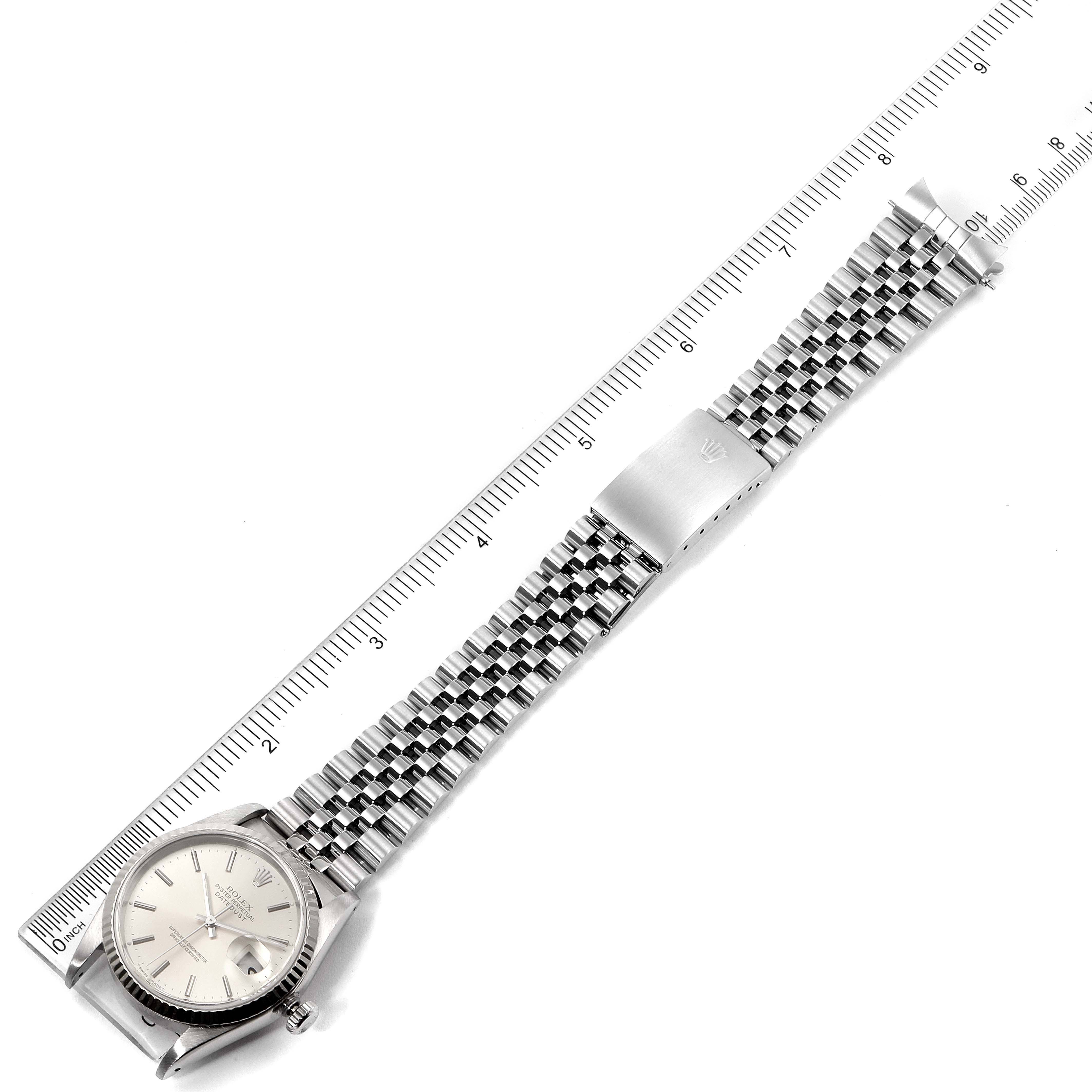 The image shows a top view of a Rolex Datejust 16234 Men's Stainless Steel Silver Dial 16234 Men's Stainless Steel Silver Dial watch with its full bracelet and clasp near a ruler.