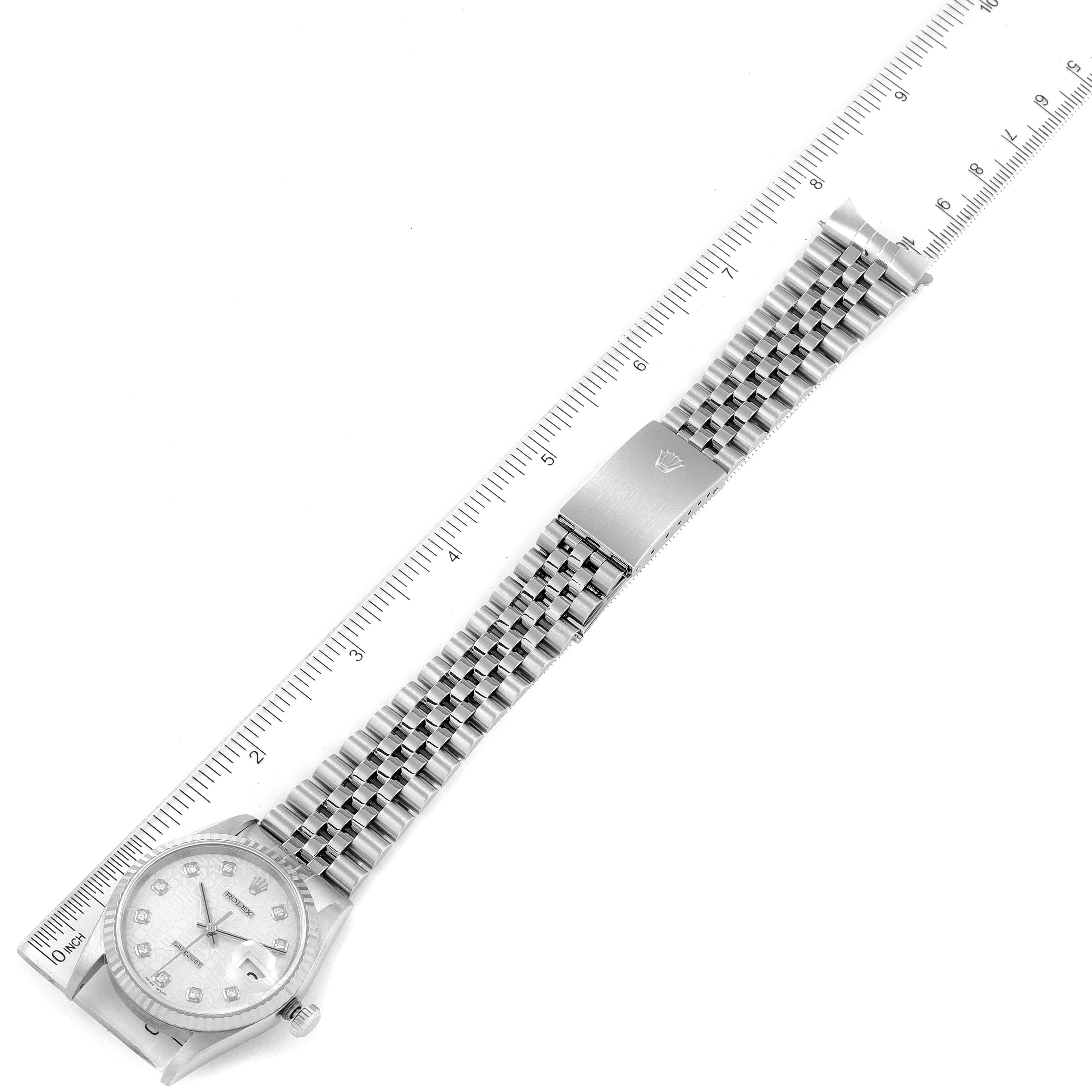 This image shows a top-down view of a Rolex Datejust 16234 Men's Stainless Steel Silver Dial 16234 Men's Stainless Steel Silver Dial watch with its silver bracelet laid beside a ruler.