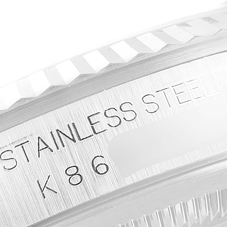 The image shows a close-up of the stainless steel fluted bezel and part of the engraving of a Rolex Datejust 16234 Men's Stainless Steel Silver Dial 16234 Men's Stainless Steel Silver Dial watch.