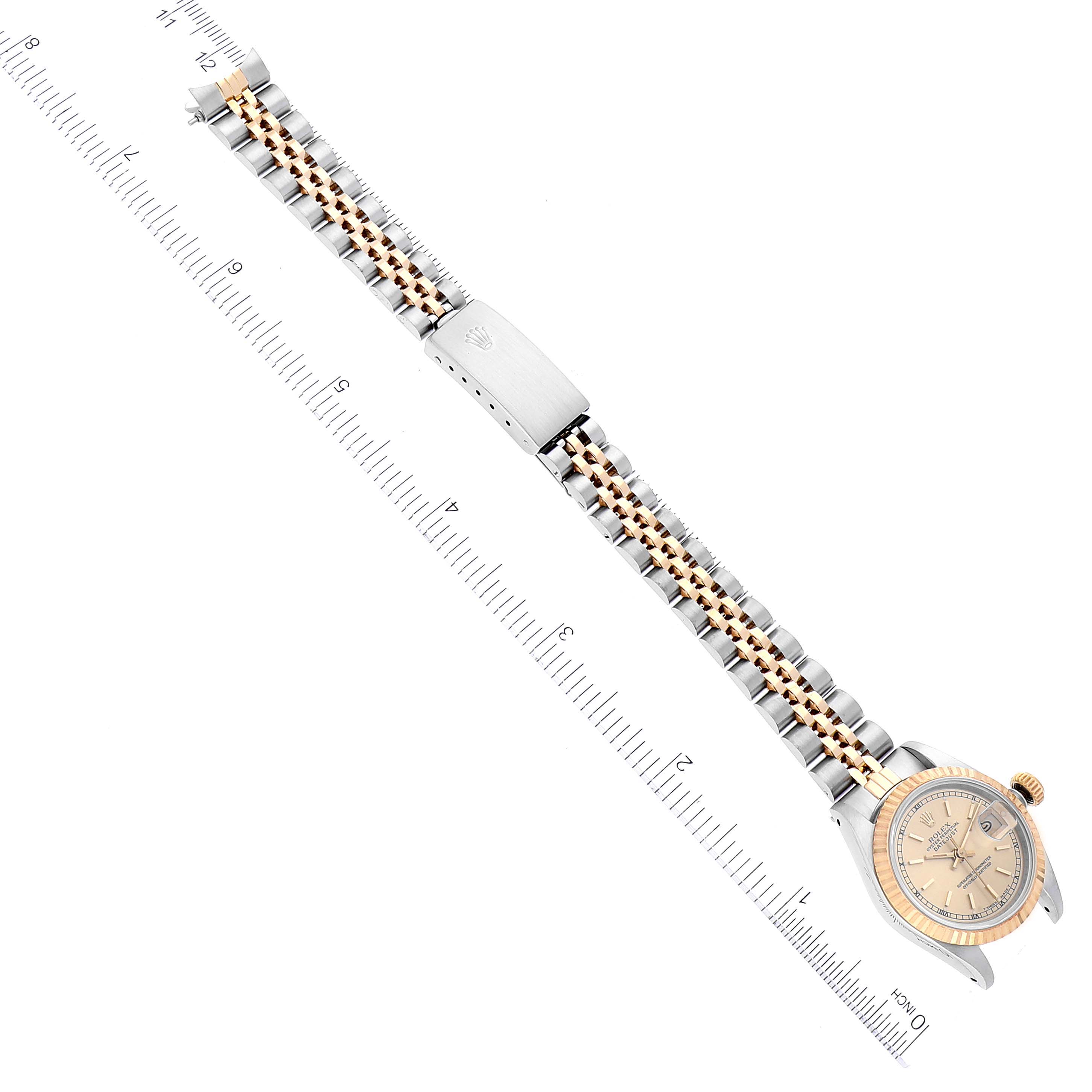 The image shows a Rolex Datejust 69173 Women's Steel and Gold (two tone) Champagne Dial 69173 Women's Steel and Gold (two tone) Champagne Dial watch laid flat with attention to its two-tone bracelet and clasp, alongside measuring rulers.