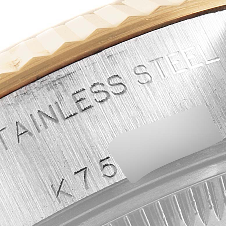 This close-up image of the Rolex Datejust 79173 Women
s Steel and Gold (two tone) Champagne Dial 79173 Women
s Steel and Gold (two tone) Champagne Dial shows a partial view of its stainless steel casing and engraved text.