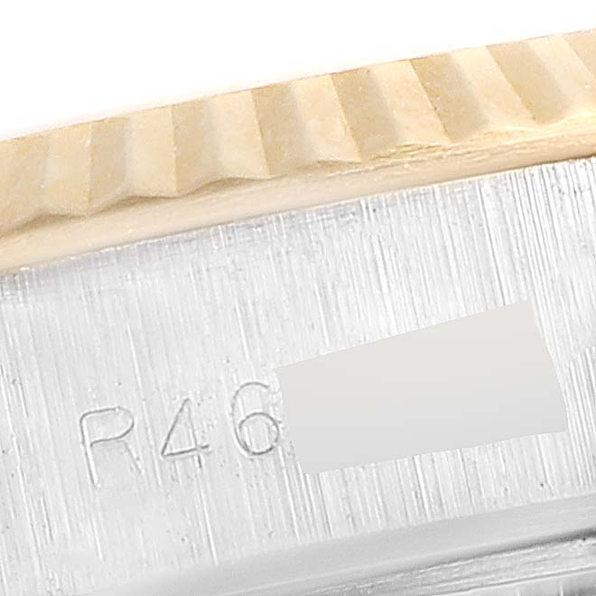 This close-up image shows a part of the engraving on the case and the fluted bezel of a Rolex Datejust 69173 Women's Steel and Gold (two tone) Champagne Dial 69173 Women's Steel and Gold (two tone) Champagne Dial watch.