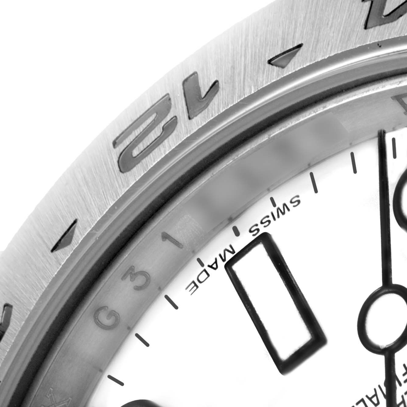 The image shows a close-up of the bezel and part of the dial of a Rolex Explorer 216570 Men's Stainless Steel White Dial 216570 Men's Stainless Steel White Dial watch.