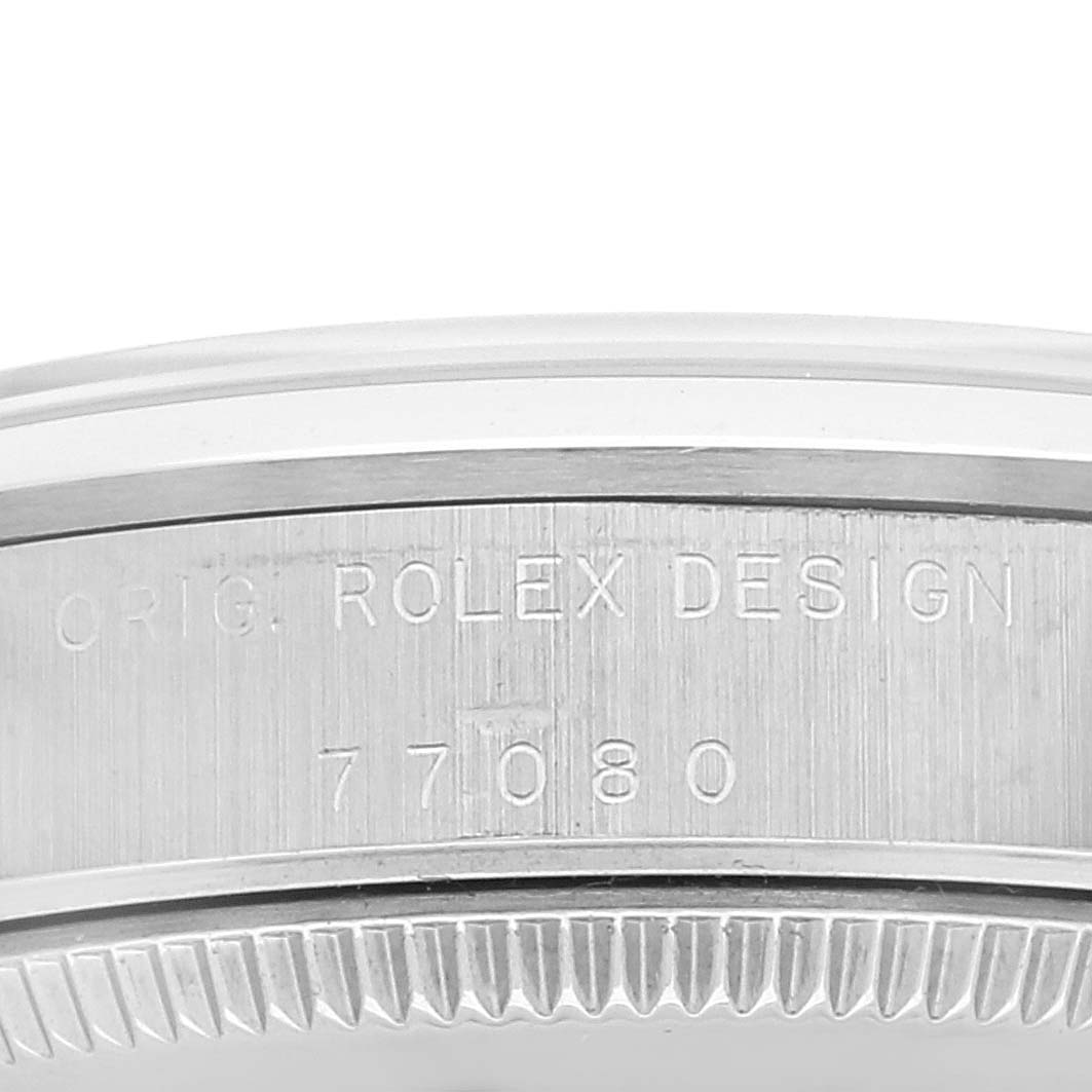This close-up image shows the etched serial number and "ORIG. ROLEX DESIGN" inscription on the case edge of the Rolex Mid-Size 77080 Women
s Stainless Steel White Dial 77080 Women
s Stainless Steel White Dial model.