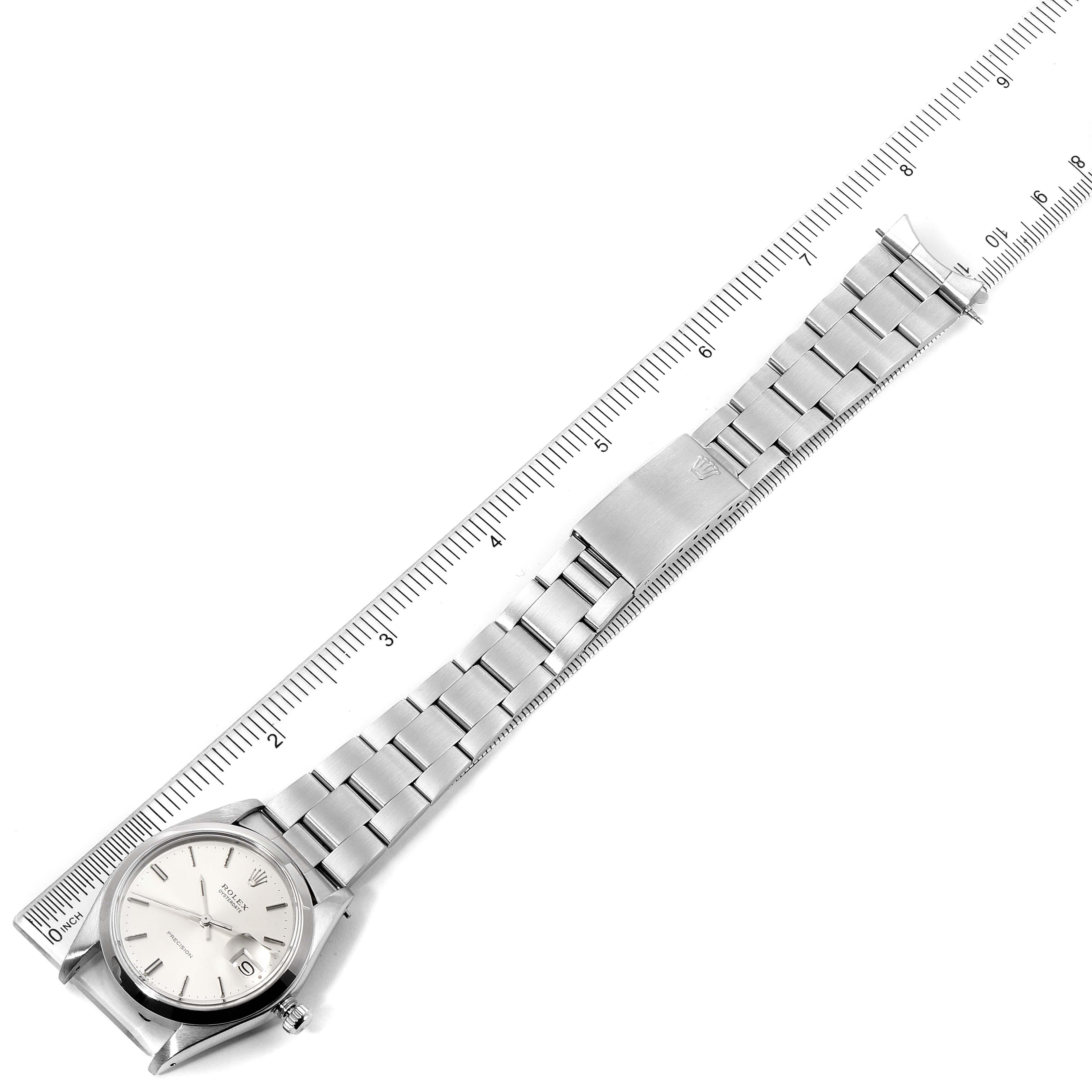 The image shows a Rolex Vintage Collection 6694 Men's Stainless Steel Silver Dial 6694 Men's Stainless Steel Silver Dial watch laid flat against a ruler, displaying its face, bracelet, and clasp.