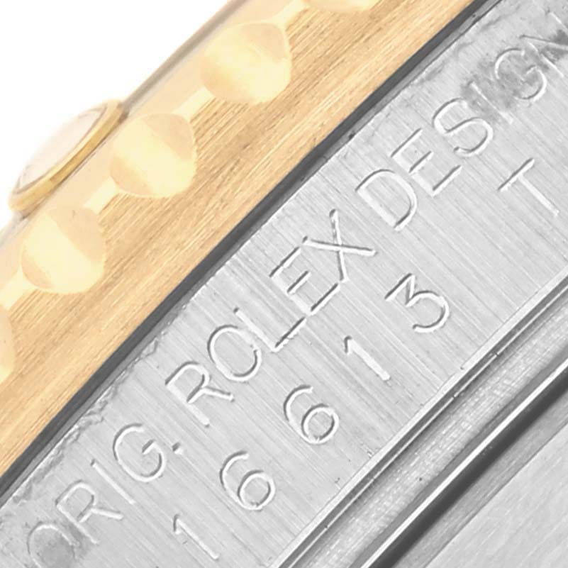 The image shows a close-up of the Rolex Submariner 16613 Men's Steel and Gold (two tone) Blue Dial 16613 Men's Steel and Gold (two tone) Blue Dial's case side, highlighting the model number engraving and bezel edge.