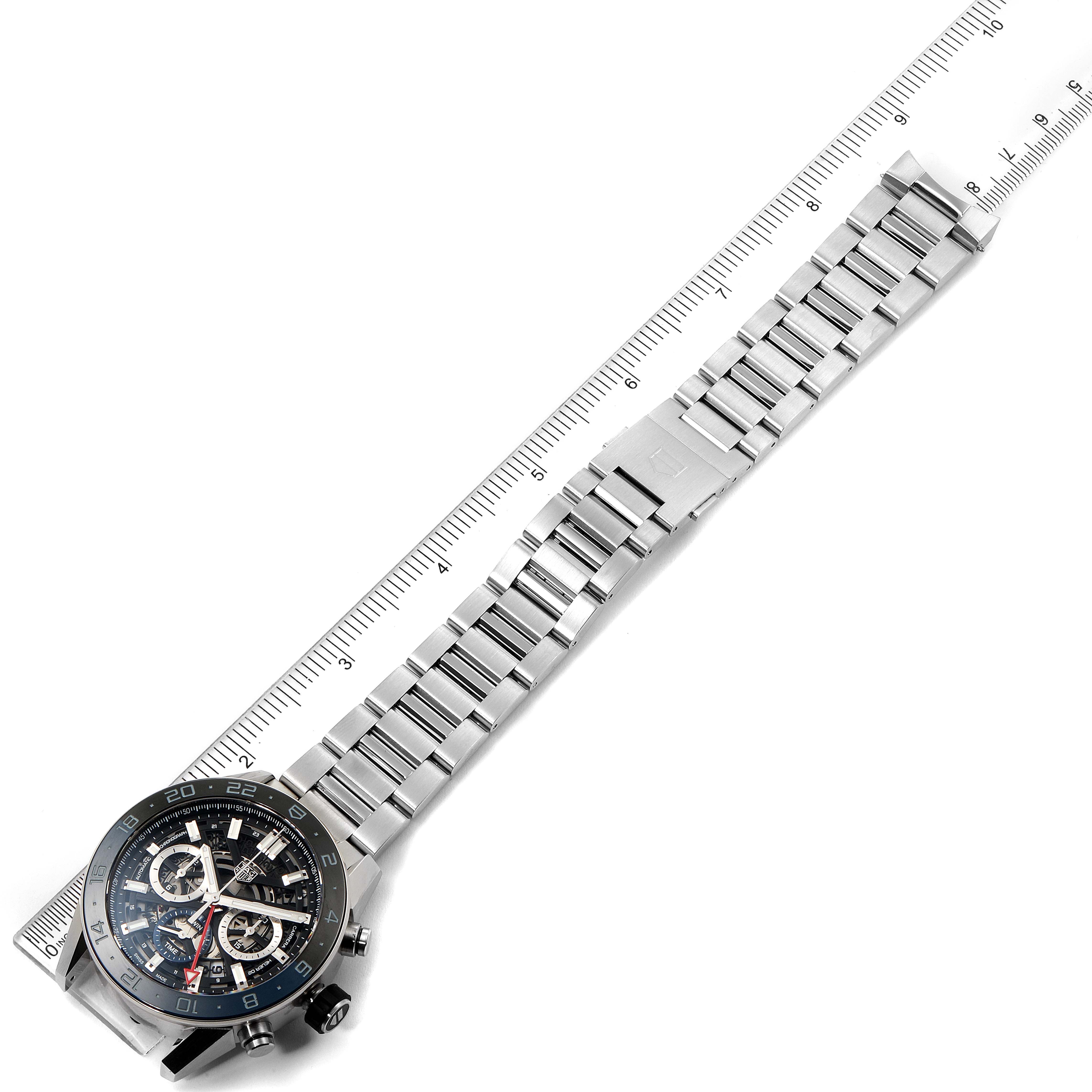 The image shows a top-down view of a Tag Heuer Carrera CBG2A1Z.BA0658 Men
s Stainless Steel Black Dial CBG2A1Z.BA0658 Men
s Stainless Steel Black Dial watch, highlighting its face and metal bracelet with a ruler for scale.