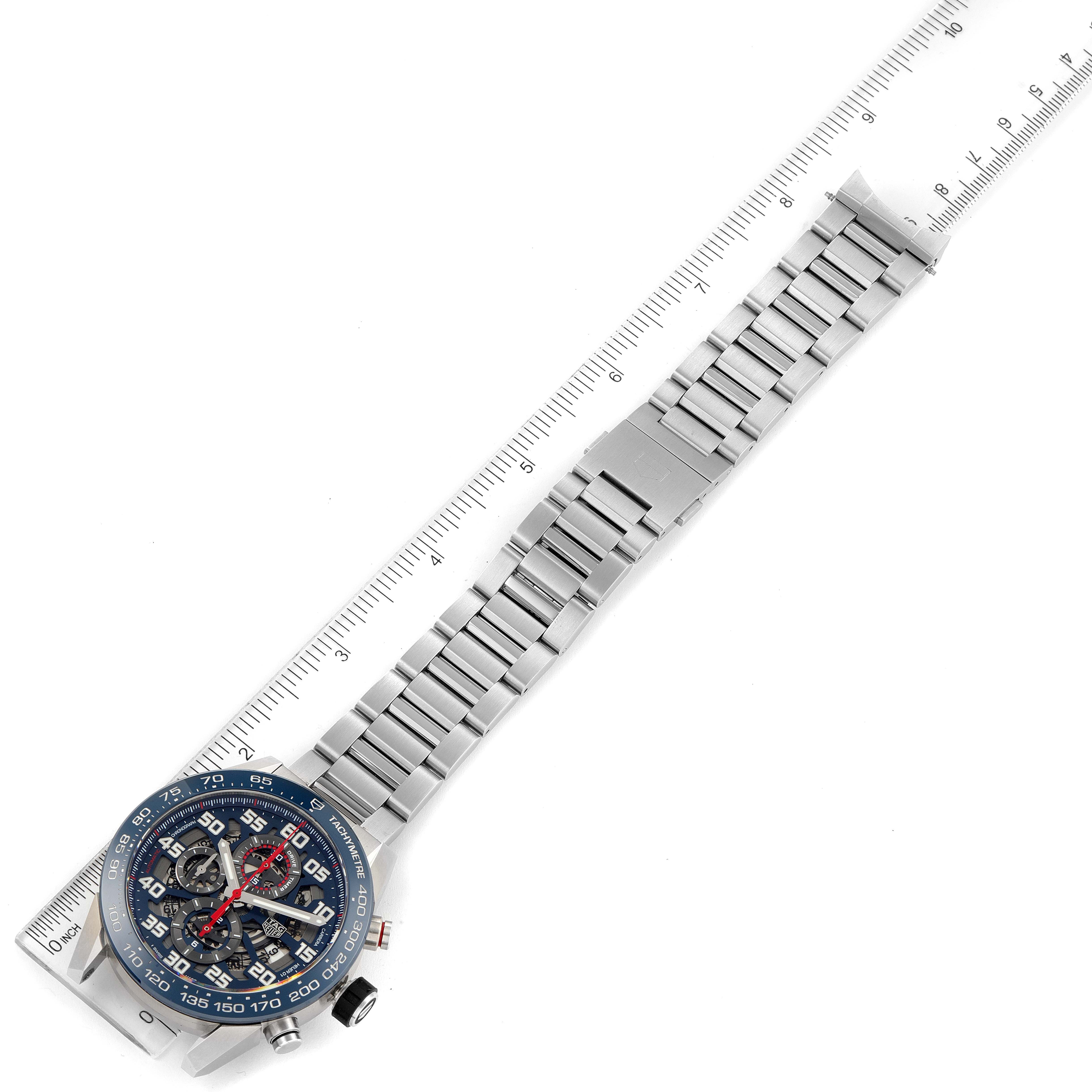 This image shows a Tag Heuer Carrera CAR2A1K.BA0703 Men
s Stainless Steel Blue Dial CAR2A1K.BA0703 Men
s Stainless Steel Blue Dial watch laid flat with its full metal band and face visible, placed on a ruler.