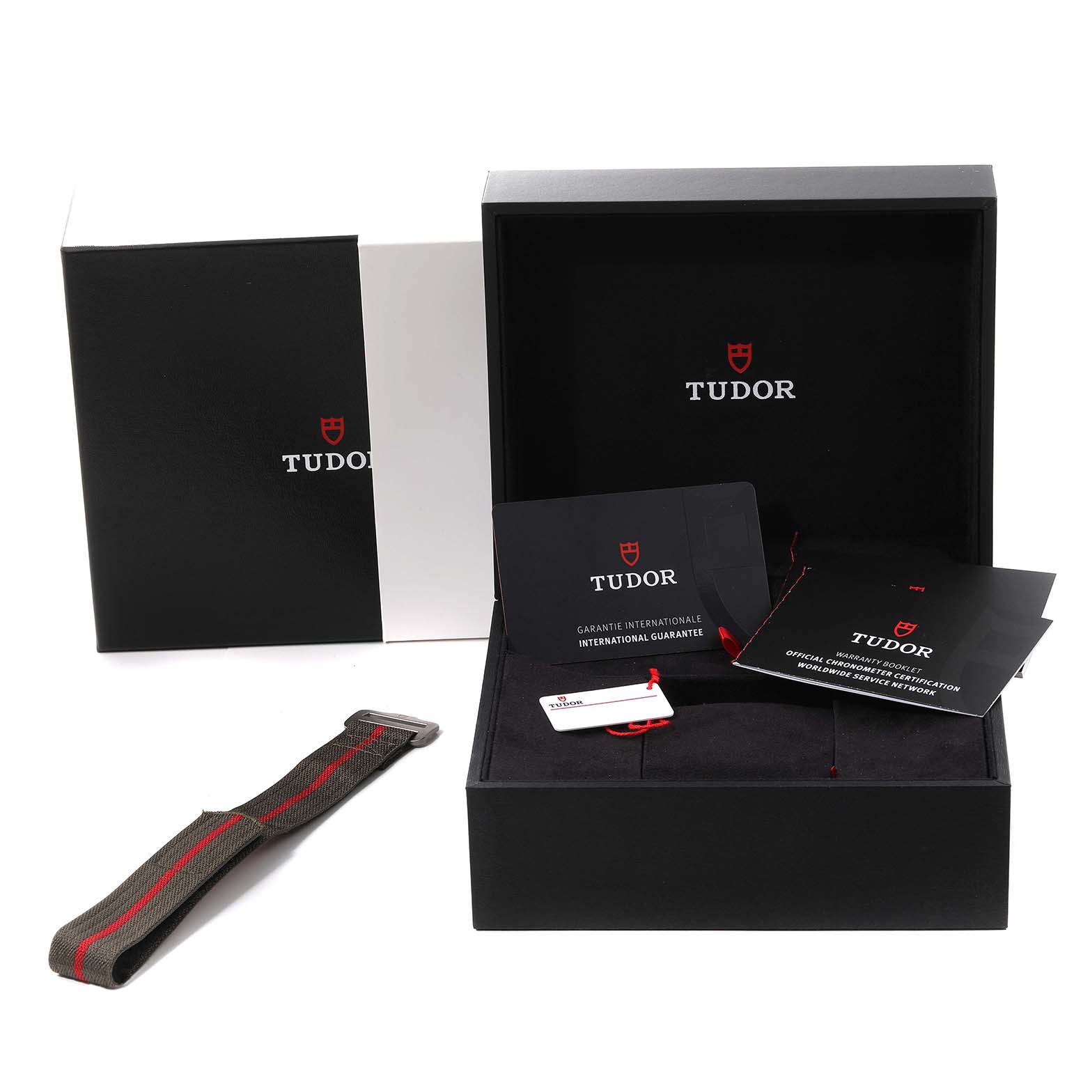 The image shows the Tudor Pelagos M25717N-0001 Men
s Titanium Black Dial M25717N-0001 Men
s Titanium Black Dial watch packaging, including a box, international guarantee cards, and an additional strap.