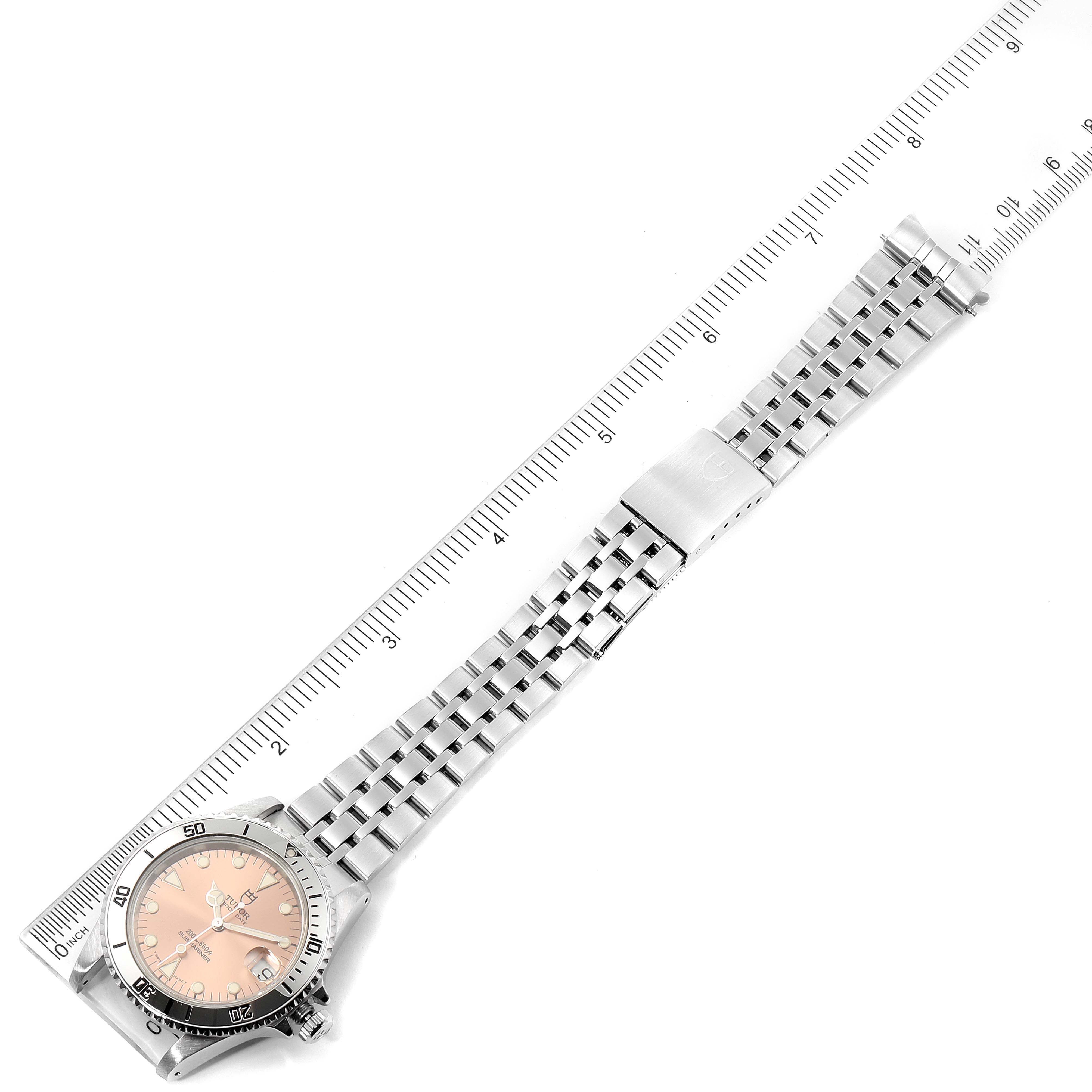 The Tudor Submariner 75190 Men's Stainless Steel Pink Dial 75190 Men's Stainless Steel Pink Dial watch is shown flat with a ruler for scale, displaying the face, bezel, and bracelet.