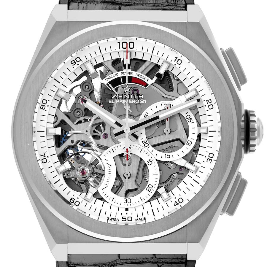 The image shows a close-up of the Zenith Defy watch face, highlighting its intricate skeleton dial and crown.