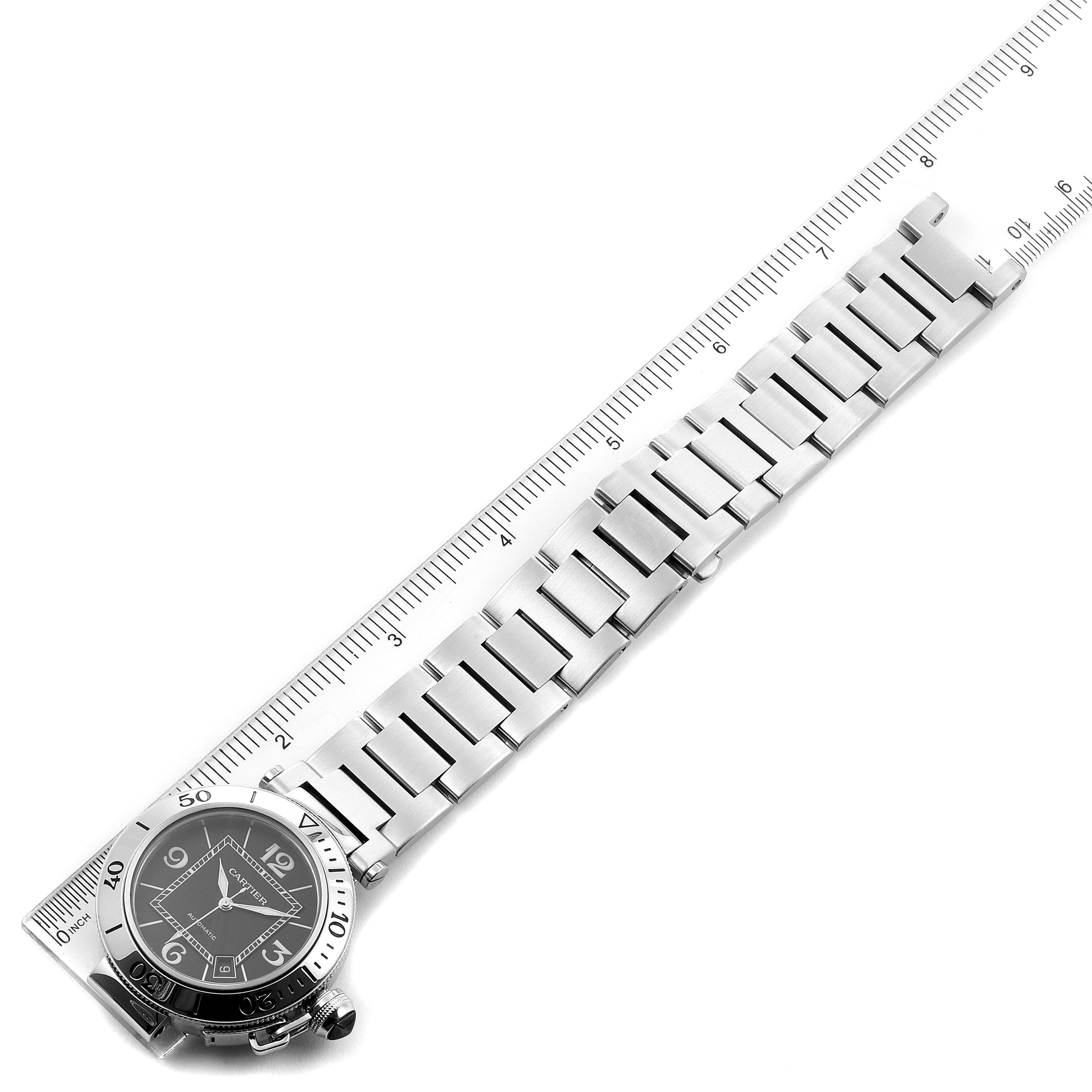 This image shows the face and full bracelet of the Cartier Pasha W31077M7 Men
s Stainless Steel Black Dial W31077M7 Men
s Stainless Steel Black Dial watch, laid flat next to a ruler for measurement.
