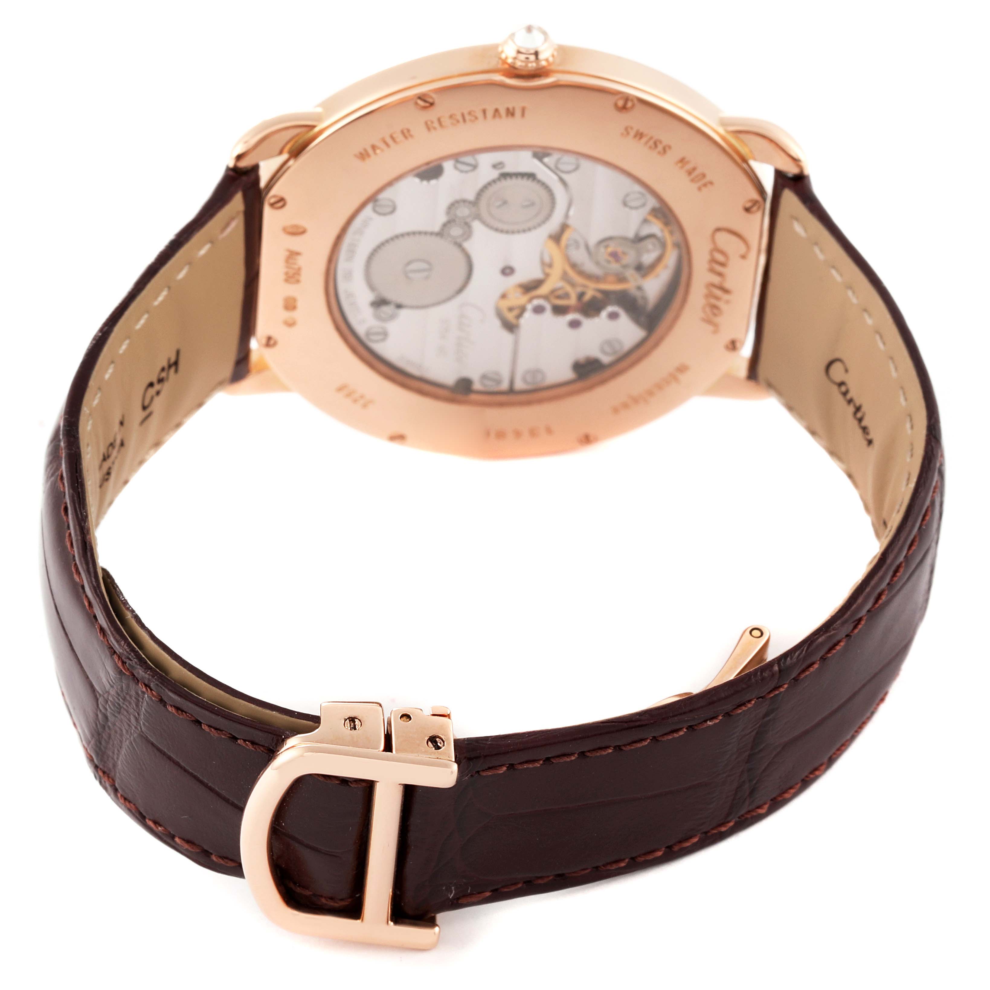 The image shows the back view and movement of the Cartier Ronde WR007001 Men
s Rose Gold Silver Dial WR007001 Men
s Rose Gold Silver Dial watch, along with its leather strap and buckle.
