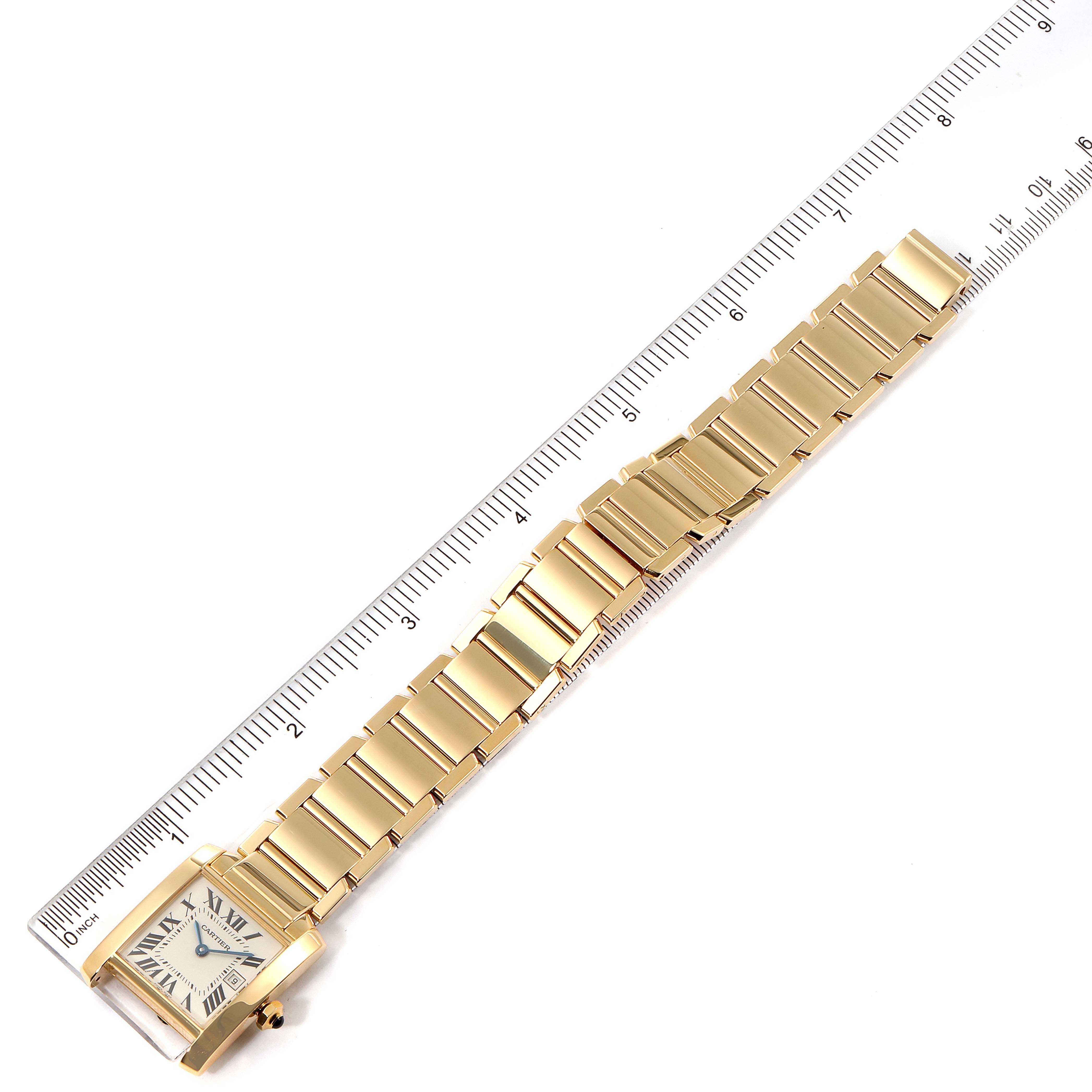 The image shows a Cartier Tank Francaise W50014N2 Women's Yellow Gold Silver Dial W50014N2 Women's Yellow Gold Silver Dial watch laid flat, highlighting its gold bracelet and square face, alongside a ruler for scale.