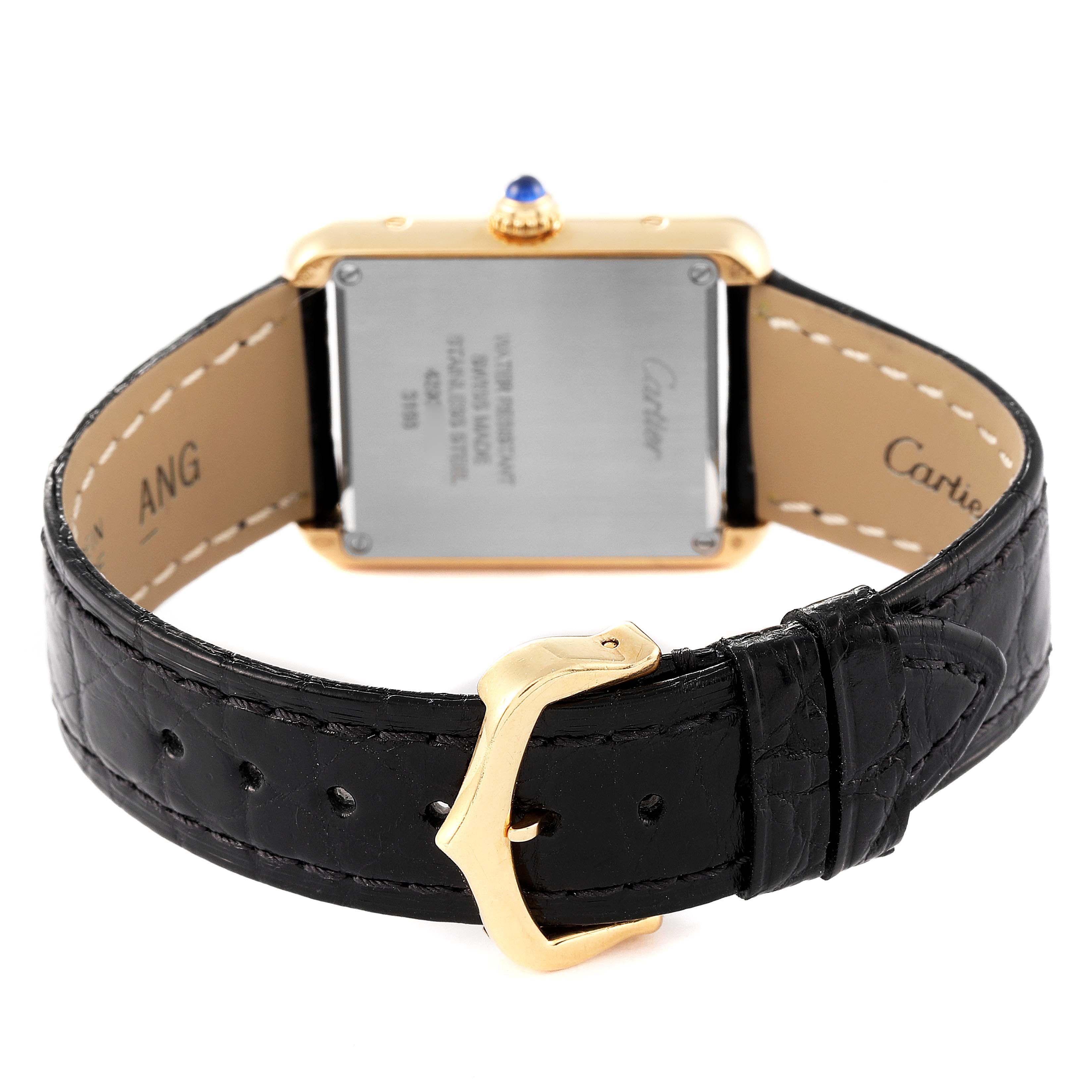 The image shows the back of the Cartier Tank Solo W5200002 Women
s Yellow Gold Silver Dial W5200002 Women
s Yellow Gold Silver Dial watch and its black leather strap with a gold buckle.