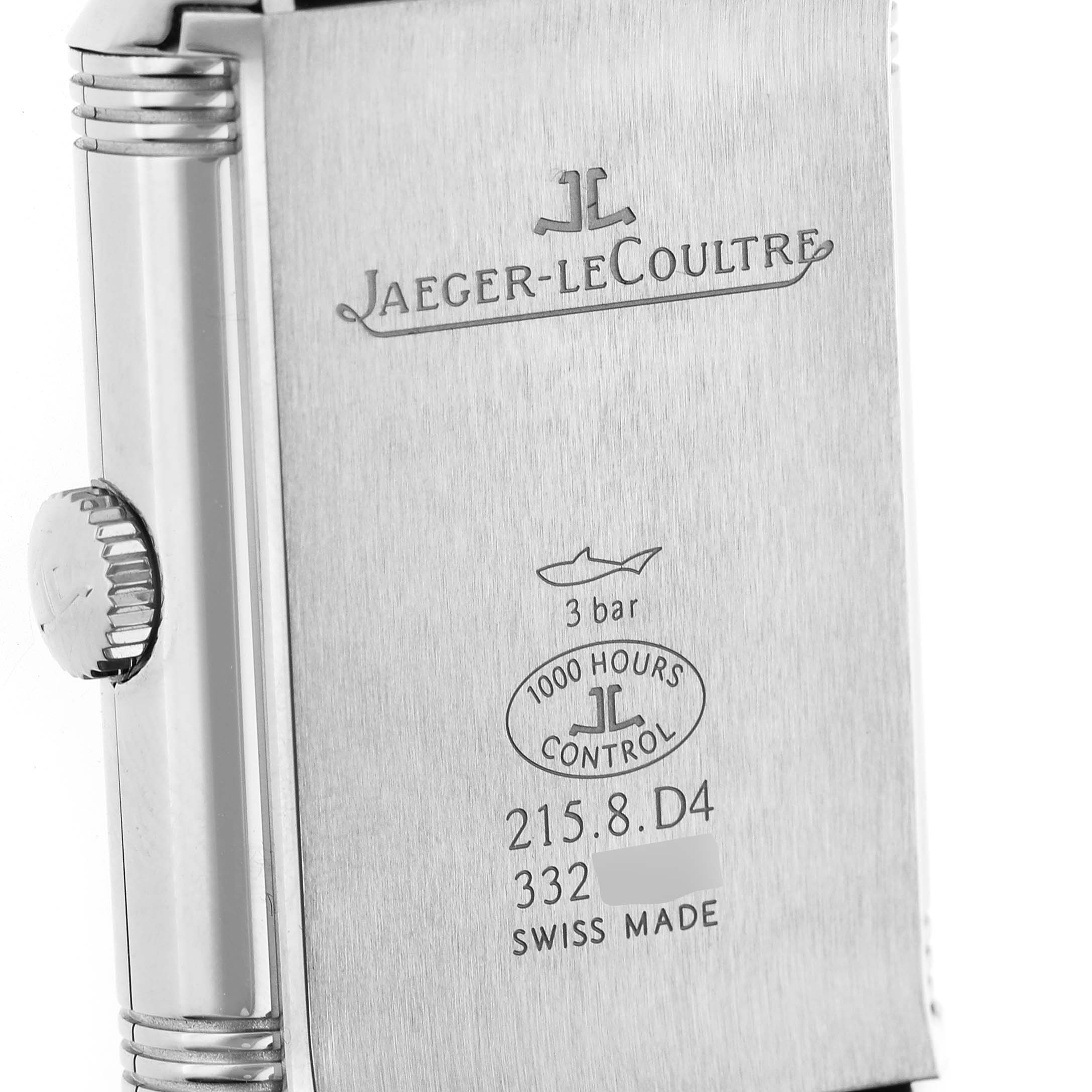 The image shows the back of a Jaeger-LeCoultre Reverso watch case with engravings and the crown visible on the side.