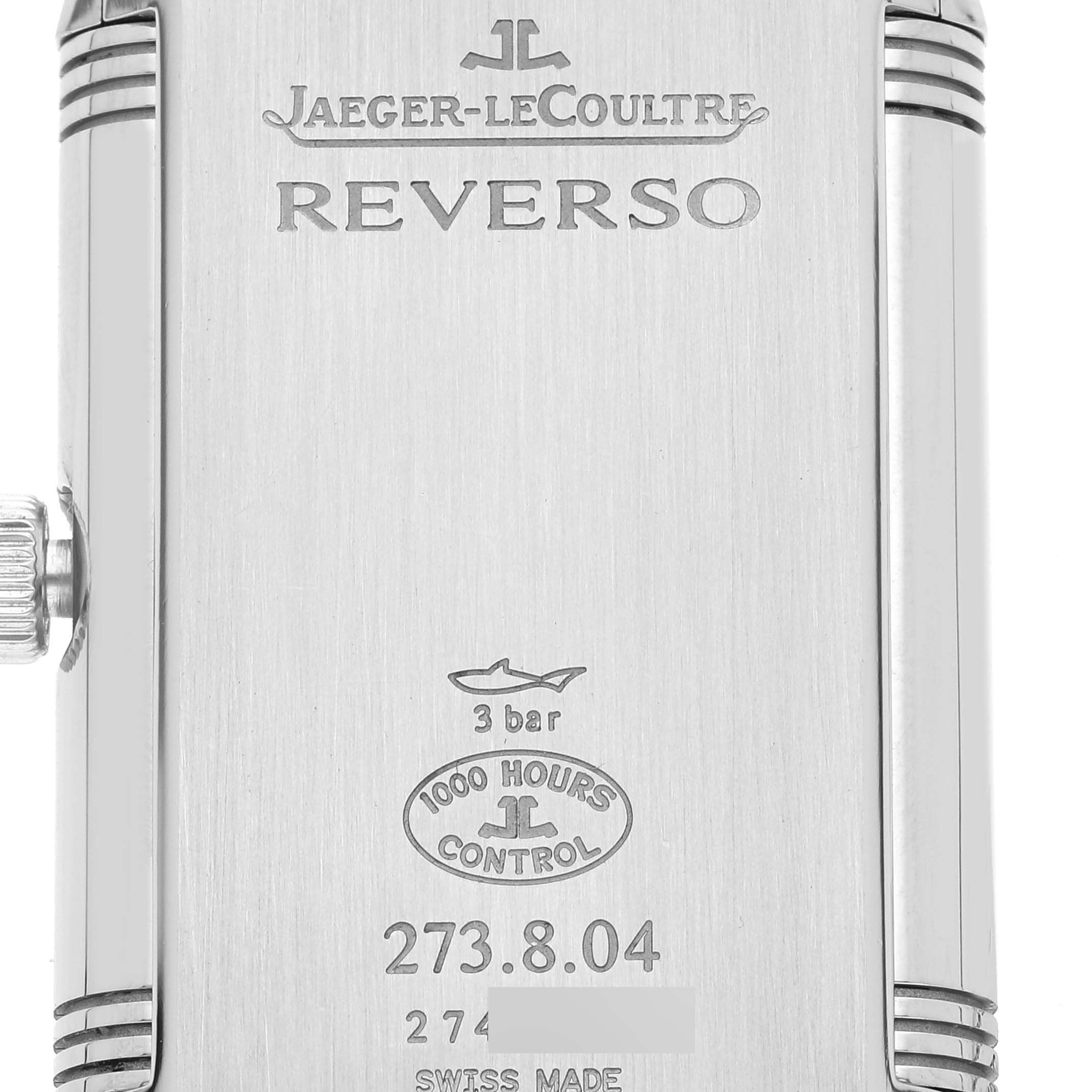 The image shows the backside of a Jaeger-LeCoultre Reverso watch with engravings and certification details.