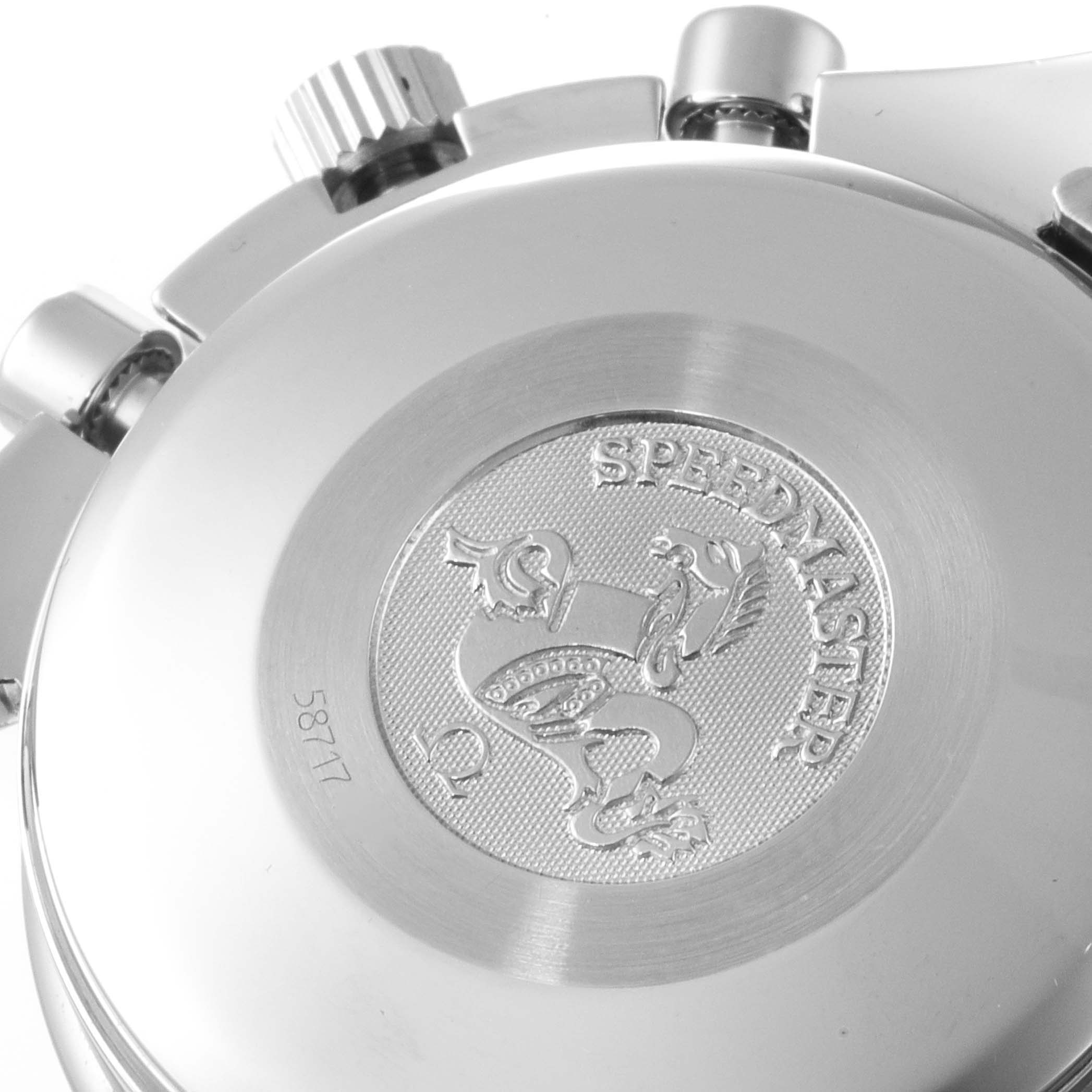The image shows the back case and part of the crown of an Omega Speedmaster 3523.30.00 Men's Stainless Steel Silver Dial 3523.30.00 Men's Stainless Steel Silver Dial watch, showcasing its engraved emblem.